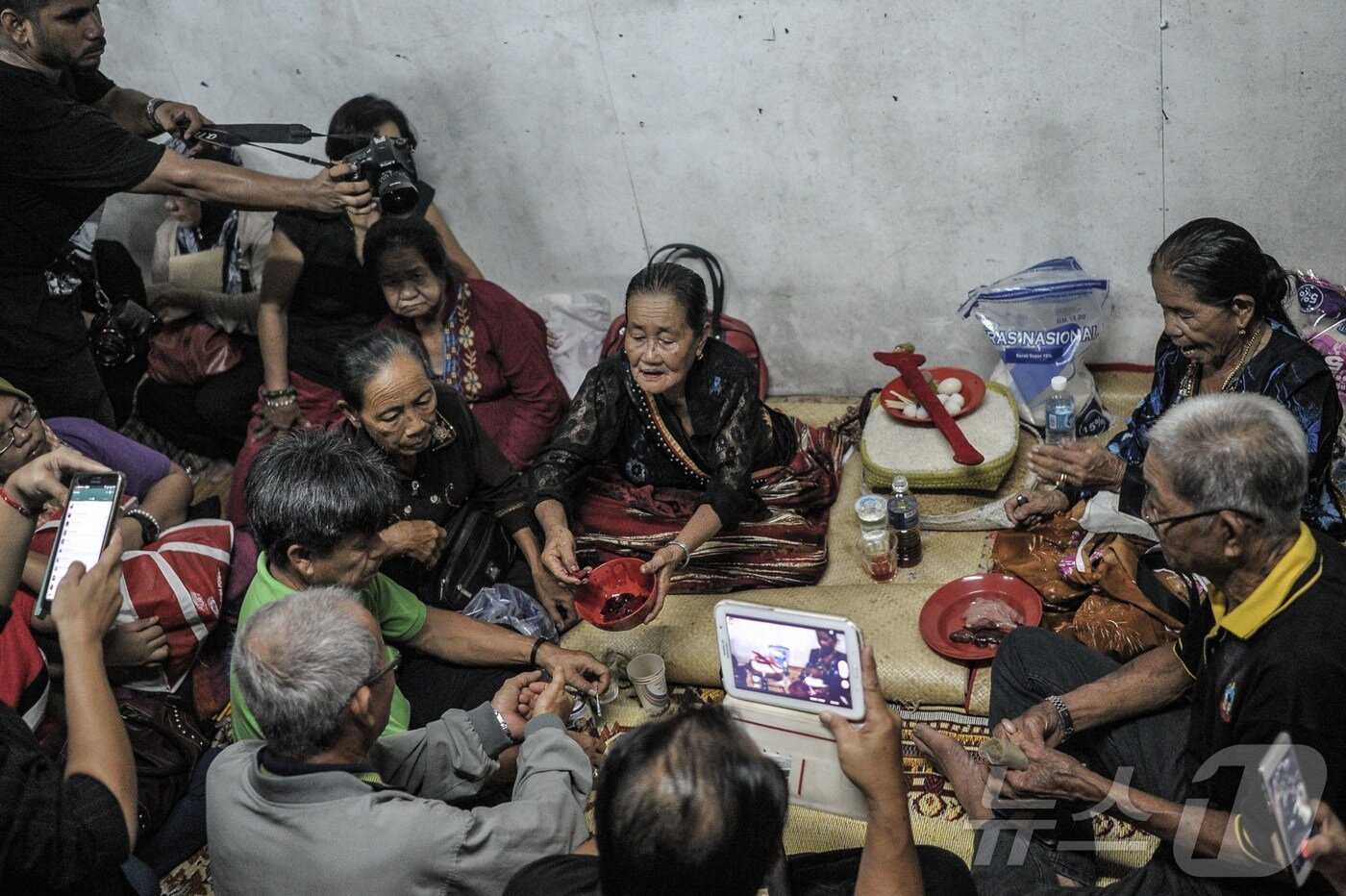 본문 이미지 - 말레이시아 보르네오섬 사바주 탐파룰리구 다맛에서 카다잔-두순 부족의 무당이종교 의식 후 제물을 바치는 모습. ⓒ AFP=뉴스1
