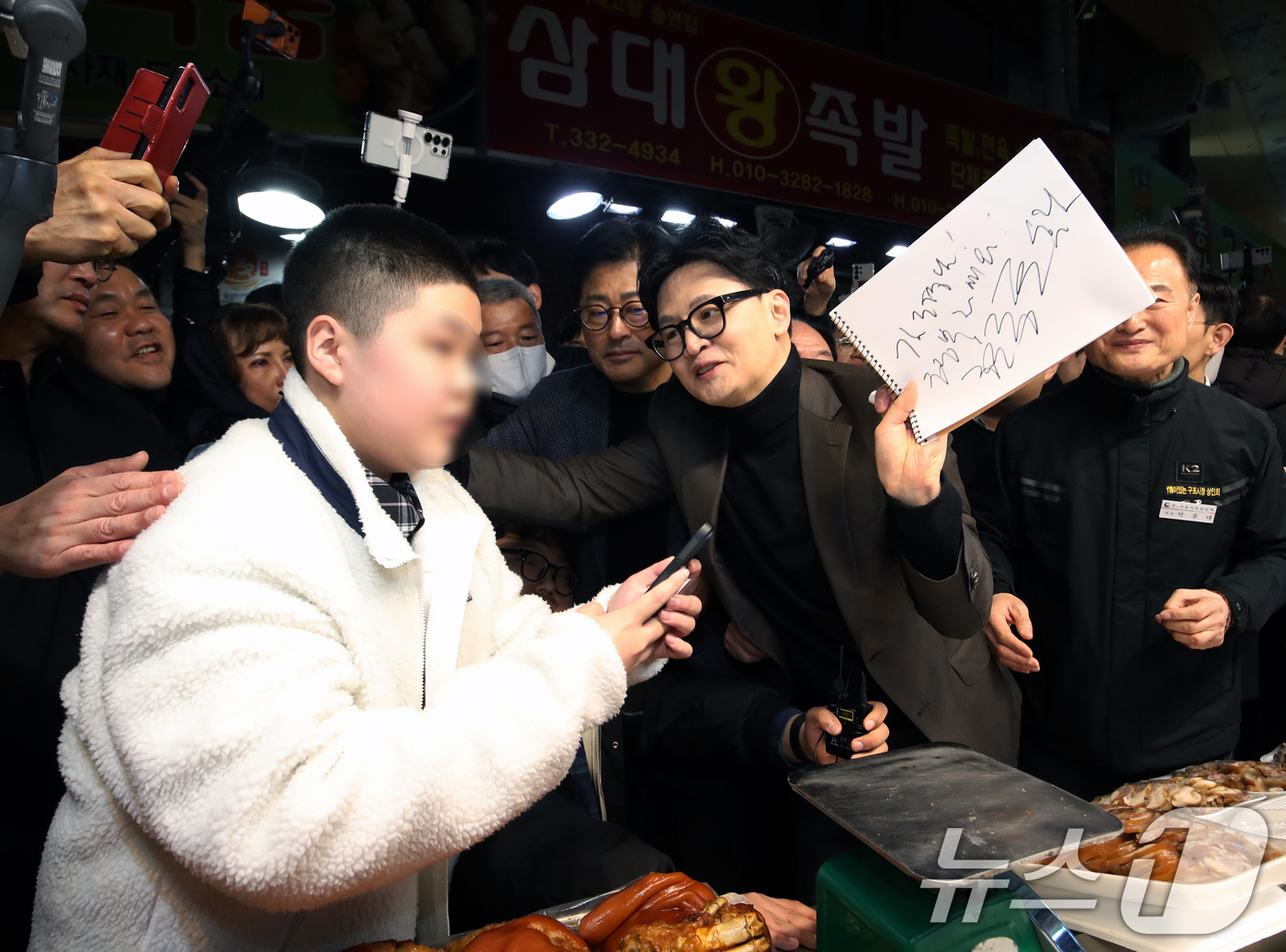 (부산=뉴스1) 윤일지 기자 = 한동훈 전 국민의힘 대표가 7일 오후 부산 북구 구포시장을 찾아 한 학생에게 사인을 해주고 있다. 2026.3.7/뉴스1