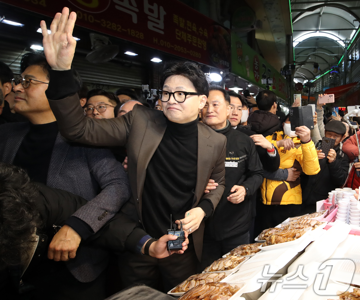 (부산=뉴스1) 윤일지 기자 = 한동훈 전 국민의힘 대표가 7일 오후 부산 북구 구포시장에서 소란이 일어나자 관계자에게 손짓을 하고 있다.  2026.3.7/뉴스1