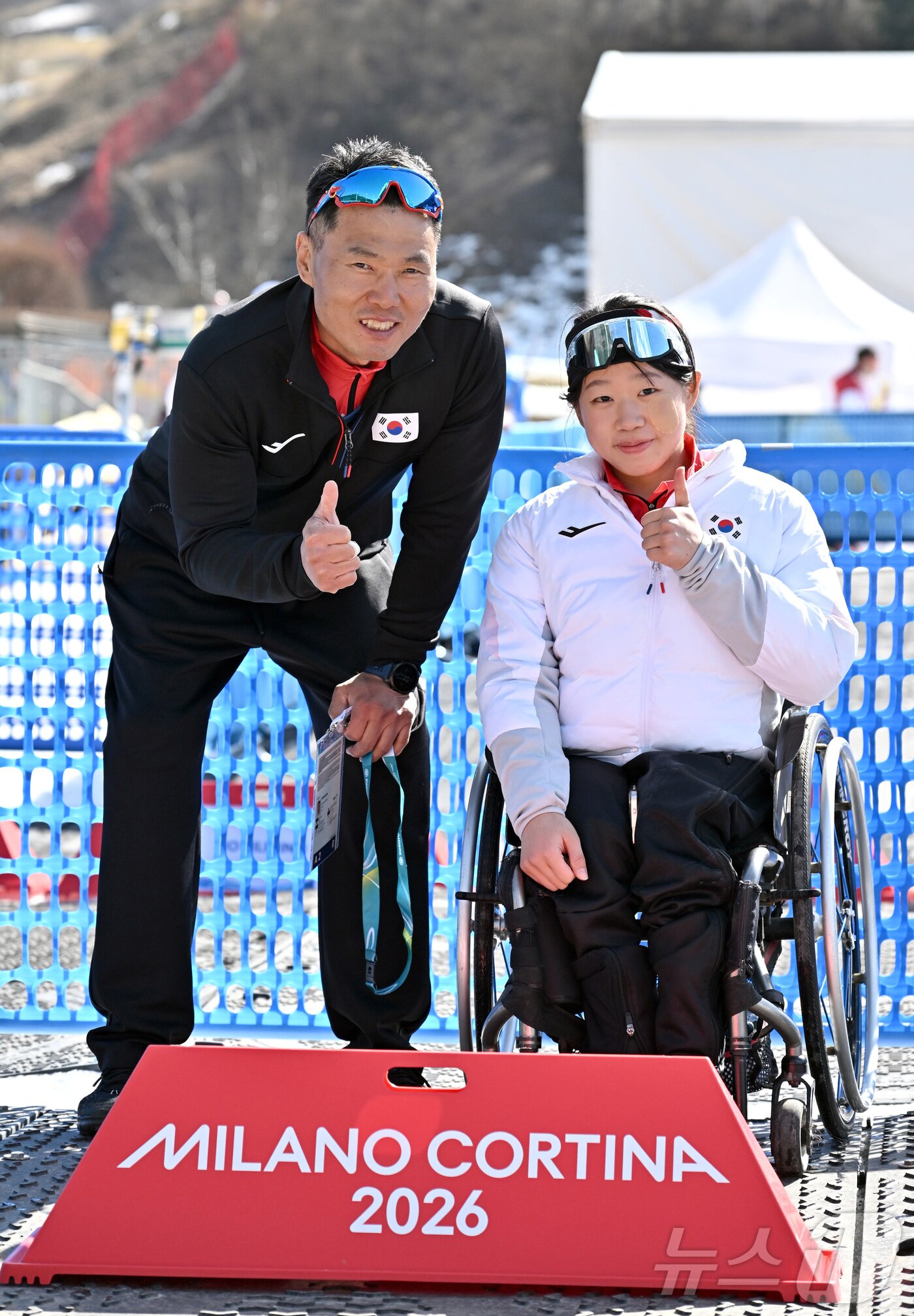 본문 이미지 - 바이애슬론 김윤지가 8일(현지시간) 이탈리아 테세로 크로스컨트리 스키 스타디움에서 열린 2026 밀라노·코르티나 동계패럴림픽 바이애슬론 여자 스프린트 좌식 12.5km 결선에서 금메달을 차지한 뒤 2018년 평창 패럴림픽 크로스컨트리에서 금메달을 딴 신의현과 기념촬영을 하고 있다. 2026.3.8 ⓒ 뉴스1 사진공동취재단