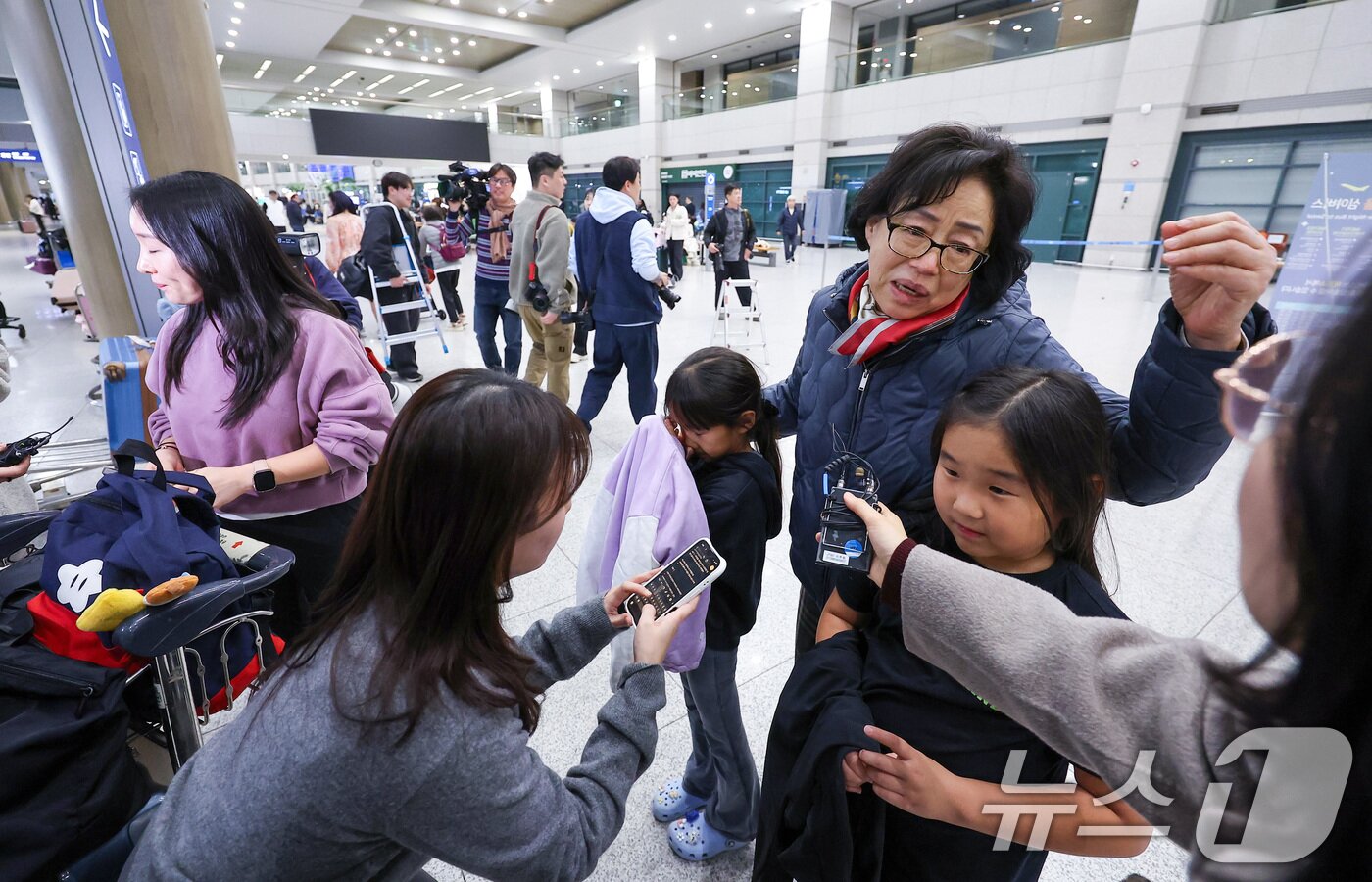 본문 이미지 - '중동 상황' 장기화로 인해 정부에서 추진한 전세기를 타고 아랍에미리트(UAE)에서 출발해 9일 새벽 인천국제공항을 통해 귀국한 승객들이 취재진과 인터뷰를 하고 있다. 2026.3.9 ⓒ 뉴스1 김성진 기자
