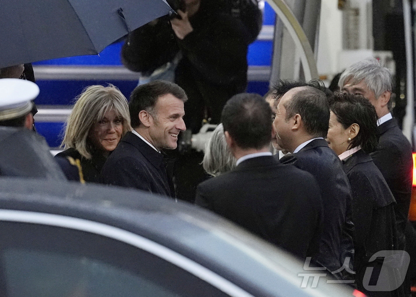 (로이터=뉴스1) 진성훈 기자 = 에마뉘엘 마크롱(가운데) 프랑스 대통령과 부인 브리지트 여사가 31일 일본 도쿄의 하네다 국제공항에 도착해 일본 측 관계자들과 환영 인사를 나누고 …