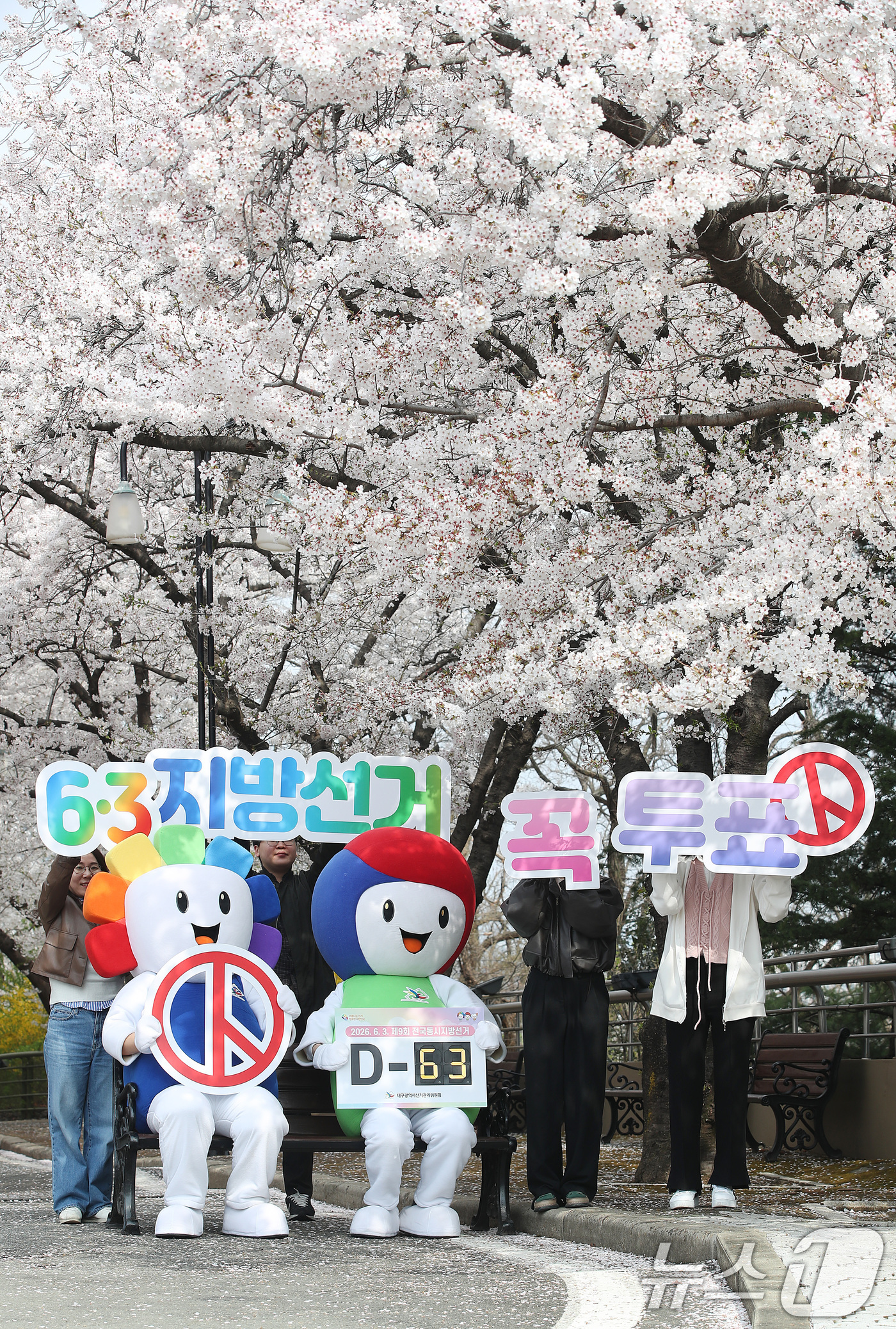 (대구=뉴스1) 공정식 기자 = 6·3 지방선거를 63일 앞둔 1일 오전 대구 달서구 테마파크 이월드에서 대구시선거관리위원회 직원과 선관위 캐릭터 '참참·바루'가 활짝 벚꽃 아래서 …