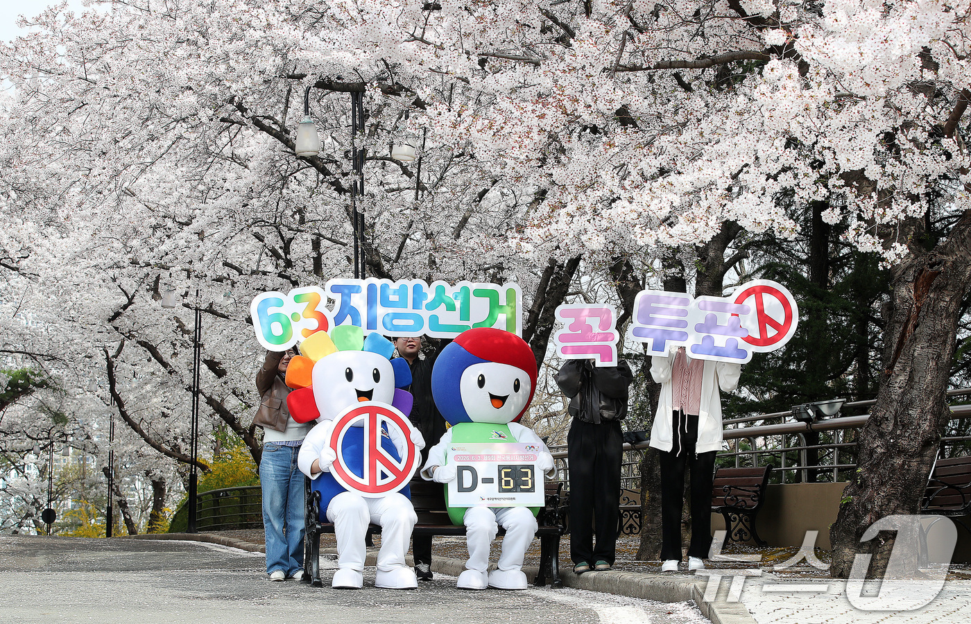 (대구=뉴스1) 공정식 기자 = 6·3 지방선거를 63일 앞둔 1일 오전 대구 달서구 테마파크 이월드에서 대구시선거관리위원회 직원과 선관위 캐릭터 '참참·바루'가 활짝 벚꽃 아래서 …