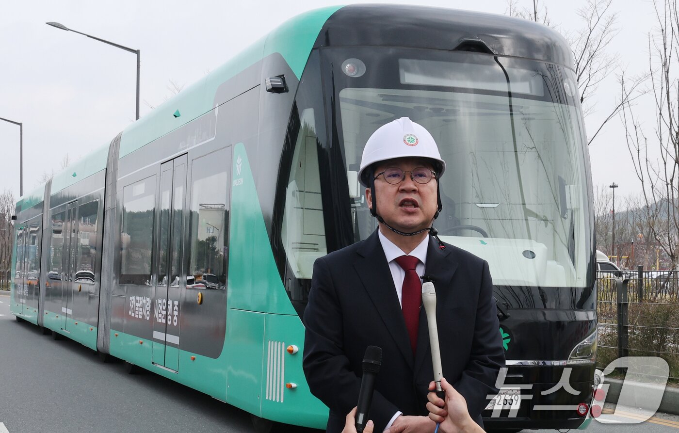 본문 이미지 - 이장우 대전시장이 1일 대전 서구 도안동 호수공원 일원에서 전국 최초 도입을 앞둔 3칸 굴절차량 앞에서 취재진의 질문에 답하고 있다. 3칸 굴절차량은 최대 230명까지 수송이 가능한 대용량 교통수단으로, 혼잡한 출퇴근 시간대 쾌적한 대중교통환경을 제공할 수 있다. 2026.4.1 ⓒ 뉴스1 김기태 기자
