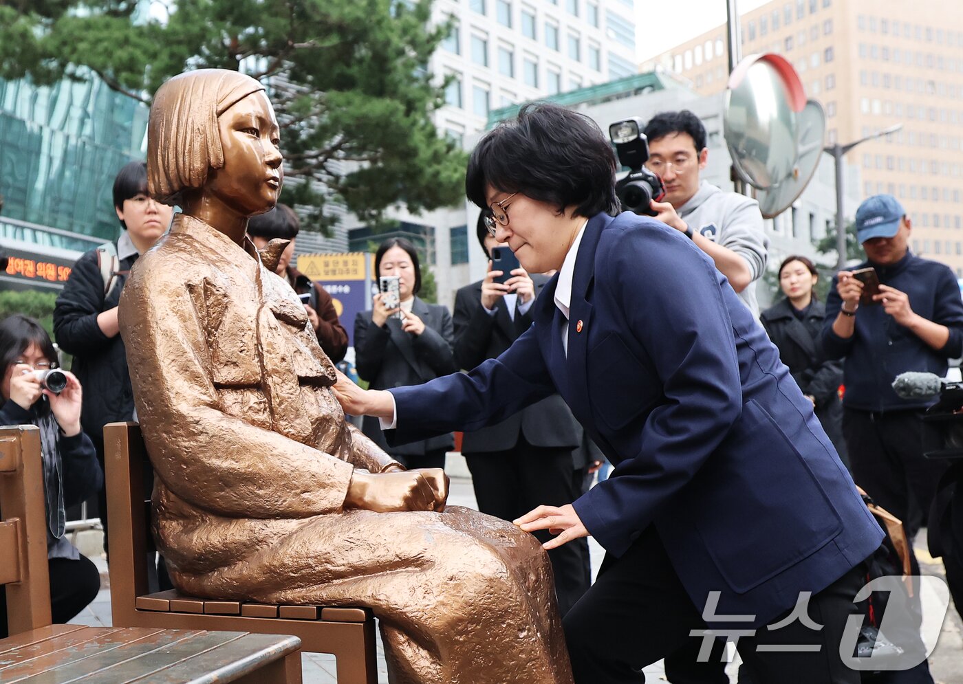 본문 이미지 - 원민경 성평등가족부 장관이 1일 서울 종로구 옛 주한 일본대사관 앞 수요시위 현장을 깜짝 방문, 6년 여 만에 바리케이드가 철거된 평화의 소녀상의 묵은 때를 벗기고 있다.   2026.4.1 ⓒ 뉴스1 오대일 기자