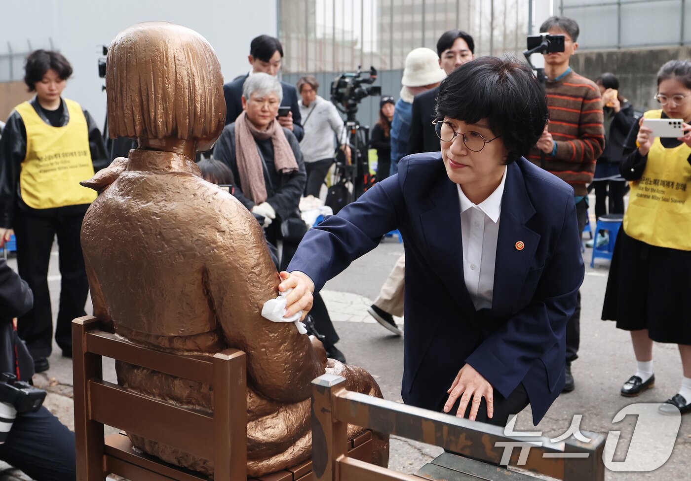 본문 이미지 - 원민경 성평등가족부 장관이 1일 서울 종로구 옛 주한 일본대사관 앞 수요시위 현장을 깜짝 방문, 6년 여 만에 바리케이드가 철거된 평화의 소녀상의 묵은 때를 벗기고 있다.  2026.4.1 ⓒ 뉴스1 오대일 기자