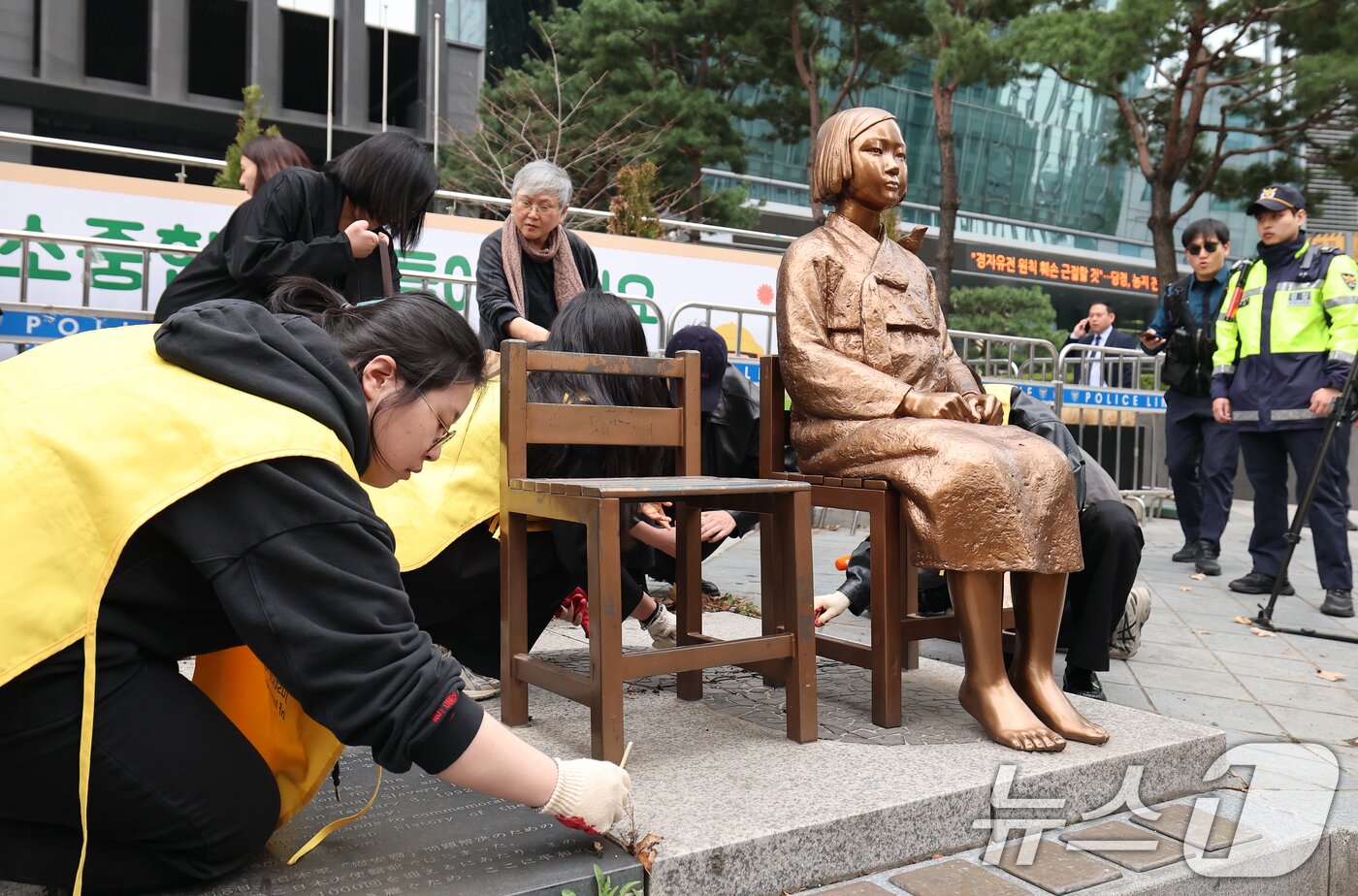 본문 이미지 - 1일 서울 종로구 옛 주한 일본대사관 앞에서 열린 제1746차 일본군 성노예제 문제해결을 위한 정기 수요시위에 앞서 정의기억연대 관계자들이 6년 여 만에 바리케이드가 철거된 평화의 소녀상의 묵은 때를 벗기고 있다.  2026.4.1 ⓒ 뉴스1 오대일 기자