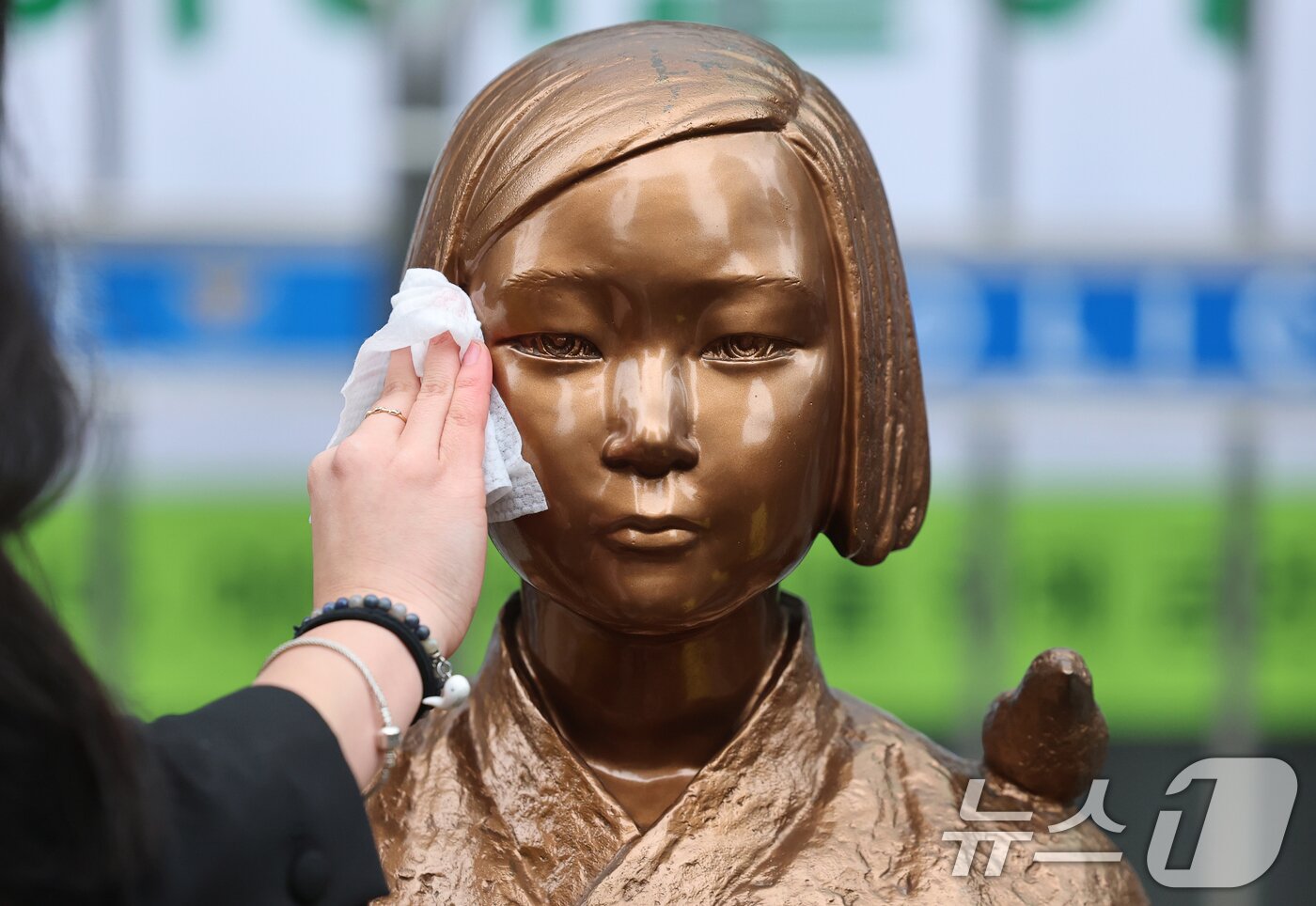 본문 이미지 - 1일 서울 종로구 옛 주한 일본대사관 앞에서 열린 제1746차 일본군 성노예제 문제해결을 위한 정기 수요시위에 앞서 정의기억연대 관계자가 6년 여 만에 바리케이드가 철거된 평화의 소녀상의 묵은 때를 벗기고 있다.  2026.4.1 ⓒ 뉴스1 오대일 기자