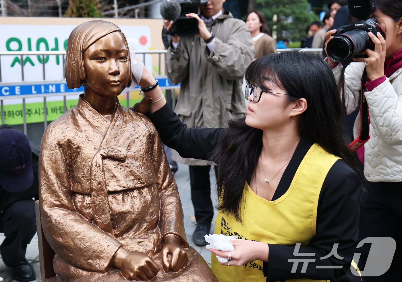본문 이미지 - 1일 서울 종로구 옛 주한 일본대사관 앞에서 열린 제1746차 일본군 성노예제 문제해결을 위한 정기 수요시위에 앞서 정의기억연대 관계자들이 6년 여 만에 바리케이드가 철거된 평화의 소녀상의 묵은 때를 벗기고 있다.  2026.4.1 ⓒ 뉴스1 오대일 기자