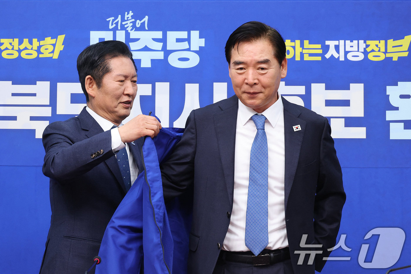 (서울=뉴스1) 신웅수 기자 = 정청래 더불어민주당 대표가 1일 서울 여의도 국회에서 열린 오중기 경북도지사 후보 환영식에서 오 후보에게 당 점퍼를 입혀주고 있다. 2026.4.1 …