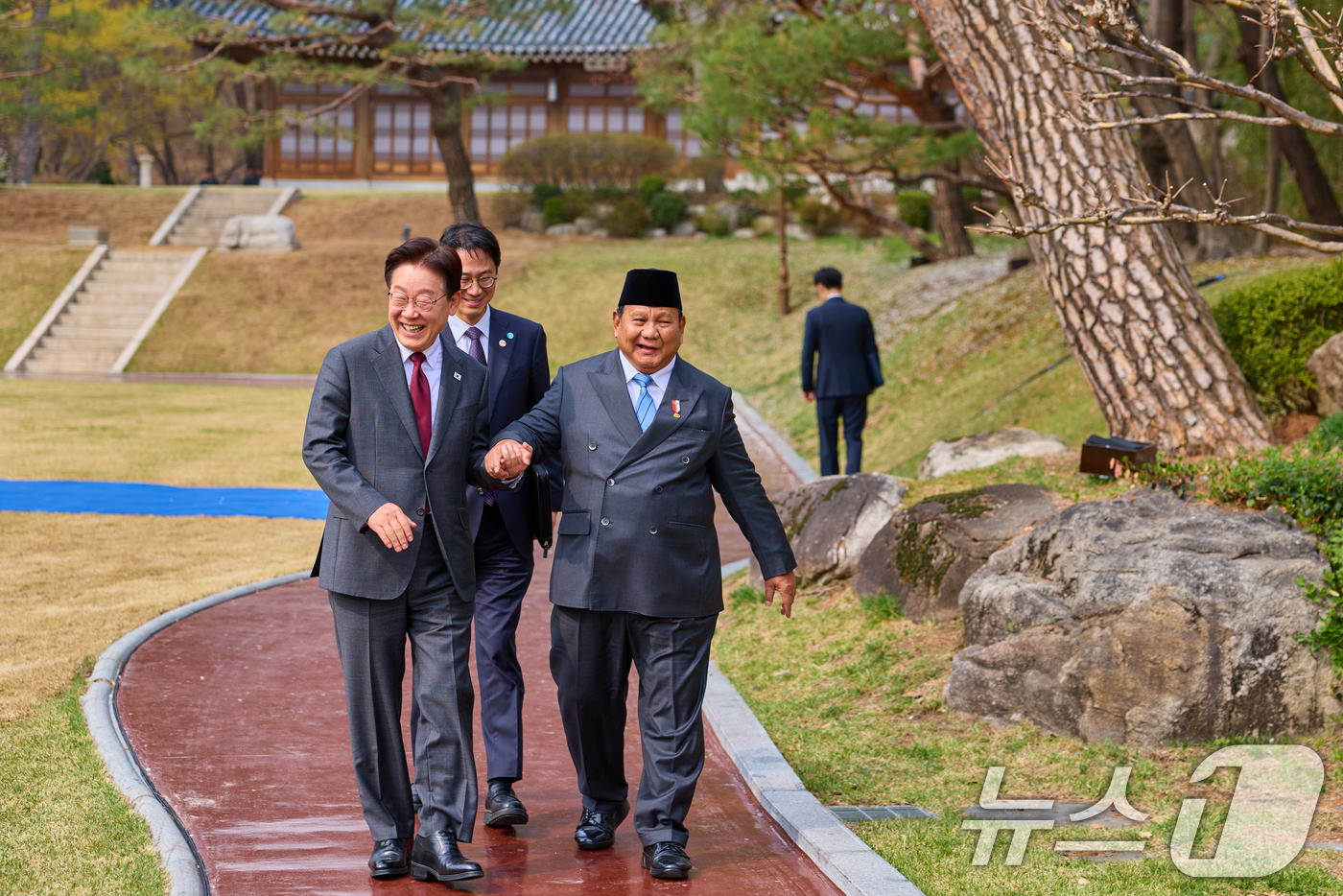 (서울=뉴스1) 허경 기자 = 이재명 대통령과 프라보워 수비안토 인도네시아 대통령이 1일 청와대 녹지원에서 열린 친교일정에서 손을 잡고 이동하고 있다. (청와대 제공. 재판매 및 …