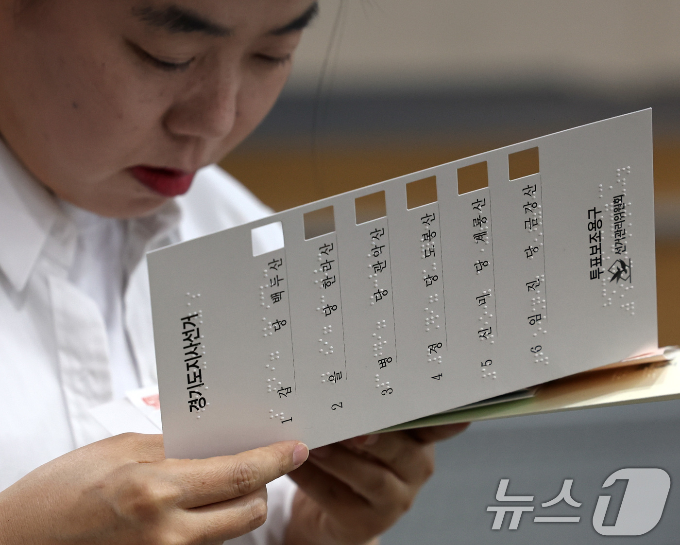 (서울=뉴스1) 구윤성 기자 = 10일 오후 서울 여의도 이룸센터에서 지방선거를 앞두고 중앙선거관리위원회 주최로 열린 모의사전투표 체험에서 참가자가 점자가 새겨진 투표보조용구를 살 …