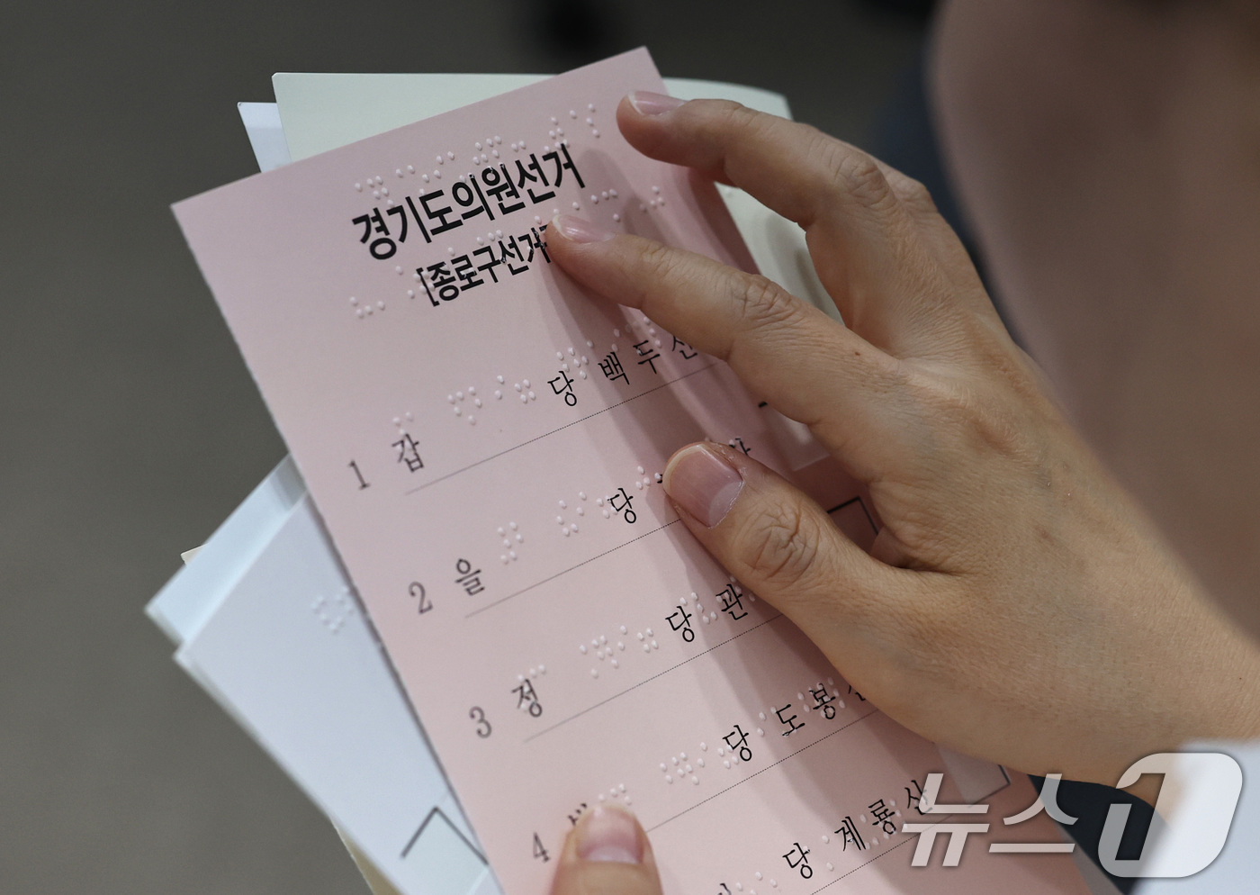 (서울=뉴스1) 구윤성 기자 = 10일 오후 서울 여의도 이룸센터에서 지방선거를 앞두고 중앙선거관리위원회 주최로 열린 모의사전투표 체험에서 참가자가 점자가 새겨진 투표보조용구를 살 …