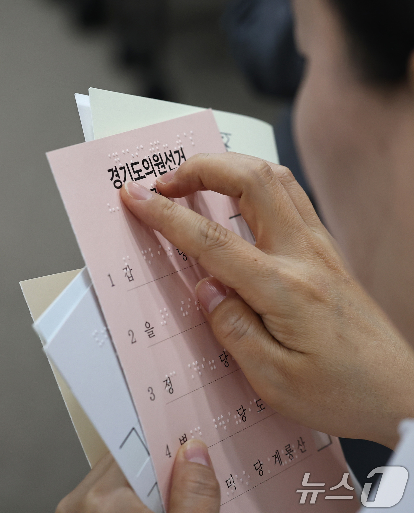 (서울=뉴스1) 구윤성 기자 = 10일 오후 서울 여의도 이룸센터에서 지방선거를 앞두고 중앙선거관리위원회 주최로 열린 모의사전투표 체험에서 참가자가 점자가 새겨진 투표보조용구를 살 …