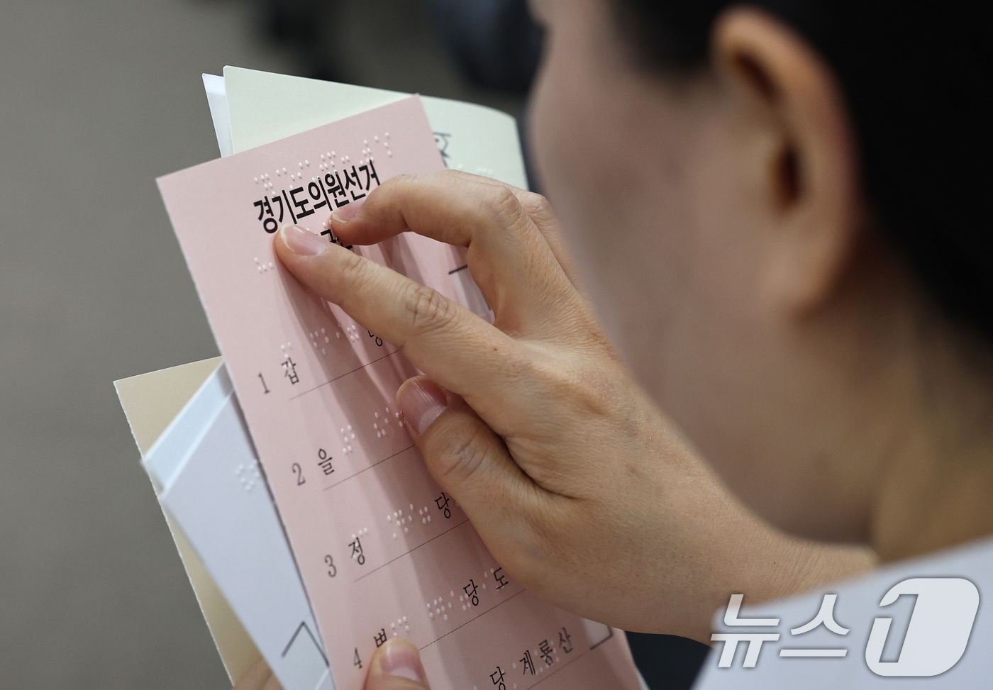 (서울=뉴스1) 구윤성 기자 = 10일 오후 서울 여의도 이룸센터에서 지방선거를 앞두고 중앙선거관리위원회 주최로 열린 모의사전투표 체험에서 참가자가 점자가 새겨진 투표보조용구를 살 …