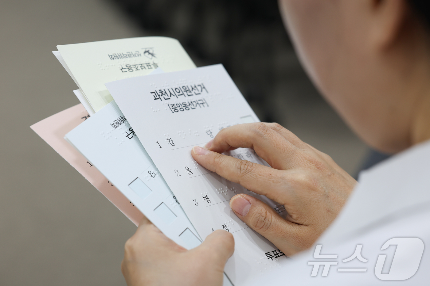 (서울=뉴스1) 이종수 인턴기자 = 10일 오후 서울 여의도 이룸센터에서 중앙선거관리위원회 주최로 열린 모의사전투표 체험에서 한 참석자가 점자로 된 투표용지를 읽고 있다. 2026 …