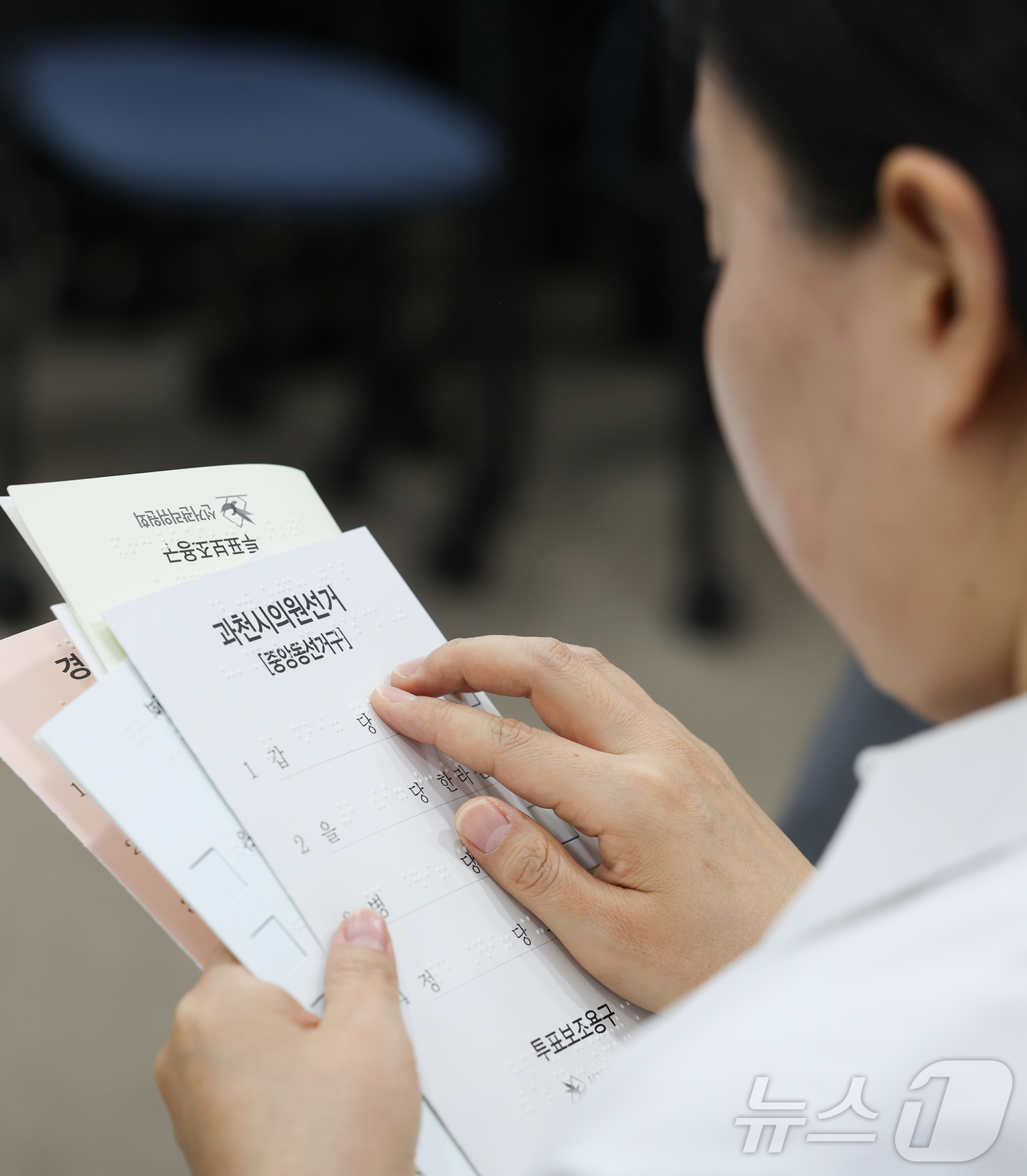 (서울=뉴스1) 이종수 인턴기자 = 10일 오후 서울 여의도 이룸센터에서 중앙선거관리위원회 주최로 열린 모의사전투표 체험에서 한 참석자가 점자로 된 투표용지를 읽고 있다. 2026 …