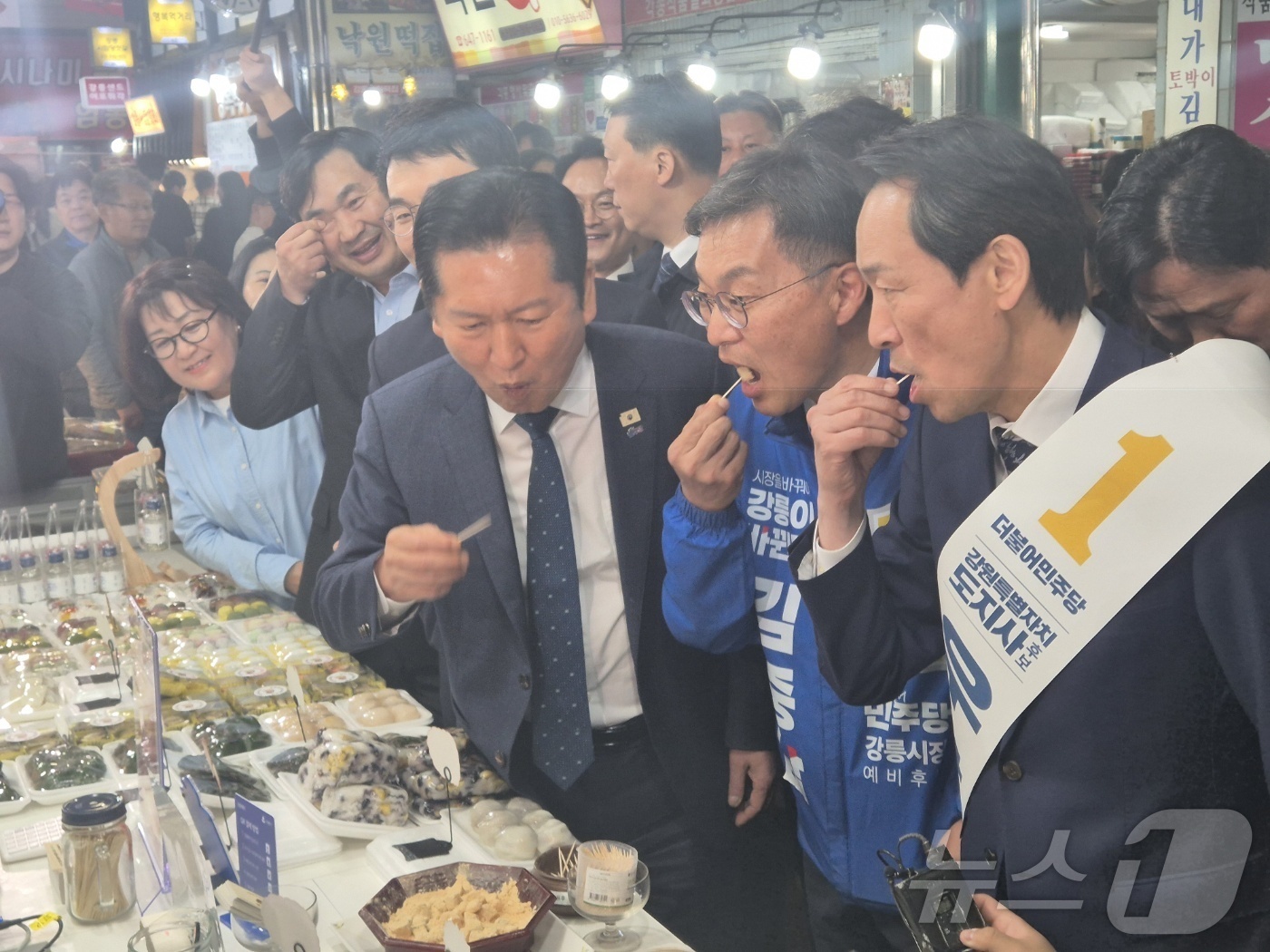 (강릉=뉴스1) 윤왕근 기자 = 정청래 더불어민주당 대표가 11일 강원 강릉중앙성남시장을 찾아 우상호 도지사 후보, 김중남 강릉시장 후보 등과 떡을 맛보고 있다. 2026.4.11 …