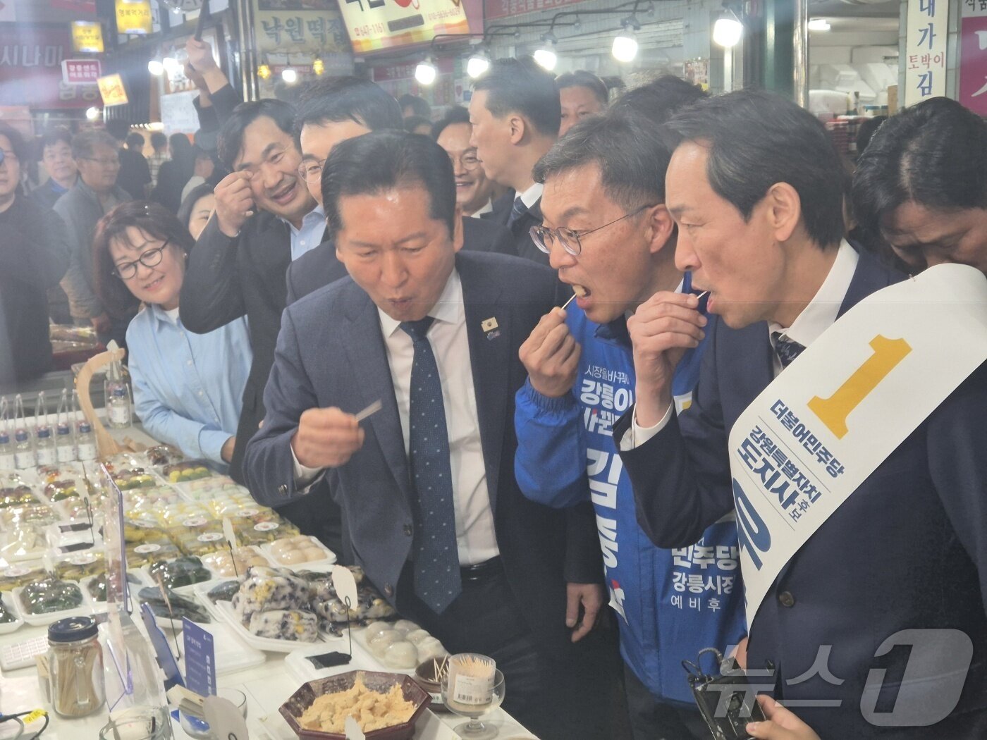 본문 이미지 - 정청래 더불어민주당 대표가 11일 강원 강릉중앙성남시장을 찾아 우상호 도지사 후보, 김중남 강릉시장 후보 등과 떡을 맛보고 있다. 2026.4.11 ⓒ 뉴스1 윤왕근 기자