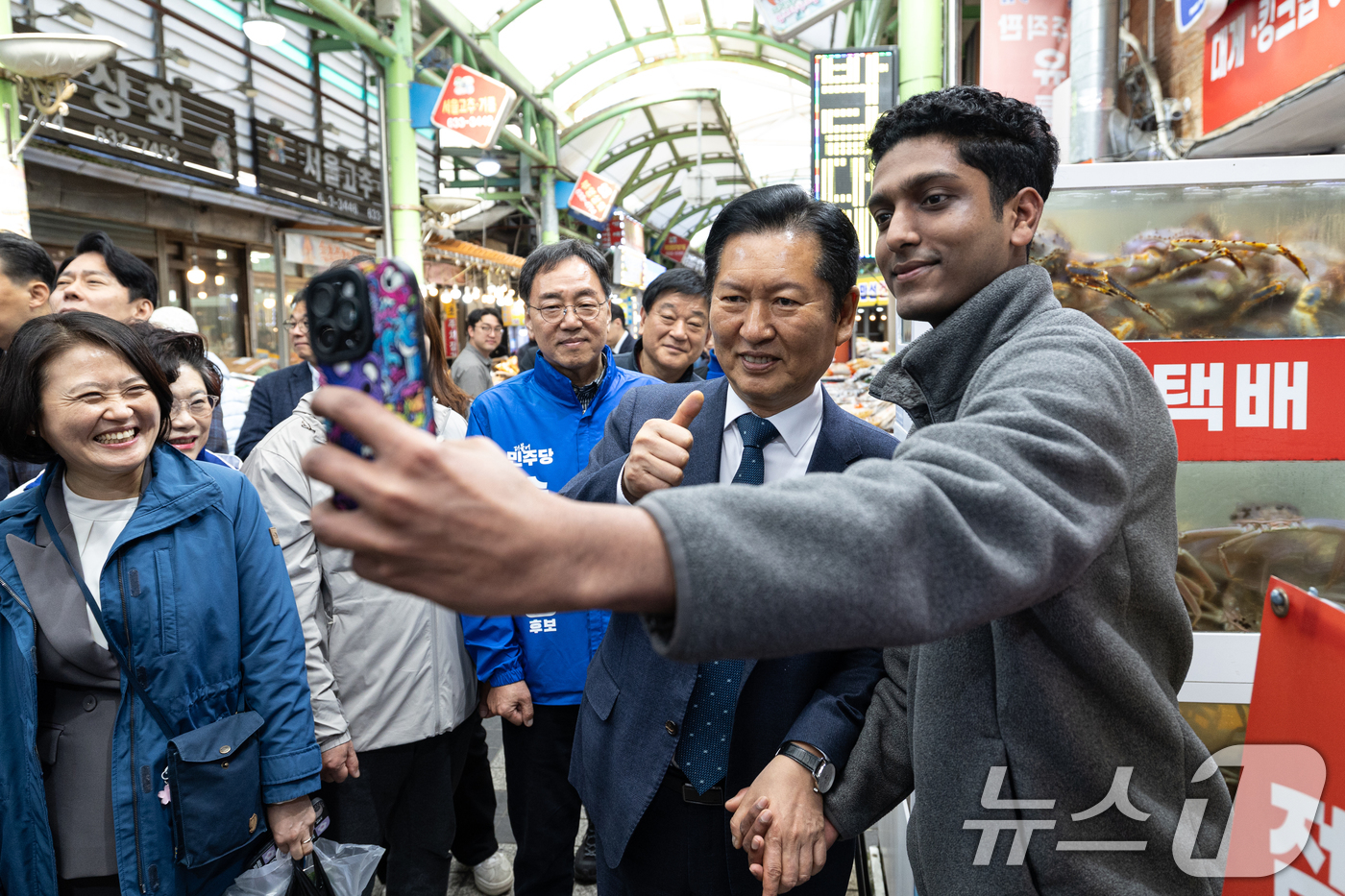 (속초=뉴스1) 이승배 기자 = 정청래 더불어민주당 대표가 12일 강원 속초관광수산시장에서 외국인 가게 직원과 기념촬영하고 있다. 2026.4.12/뉴스1