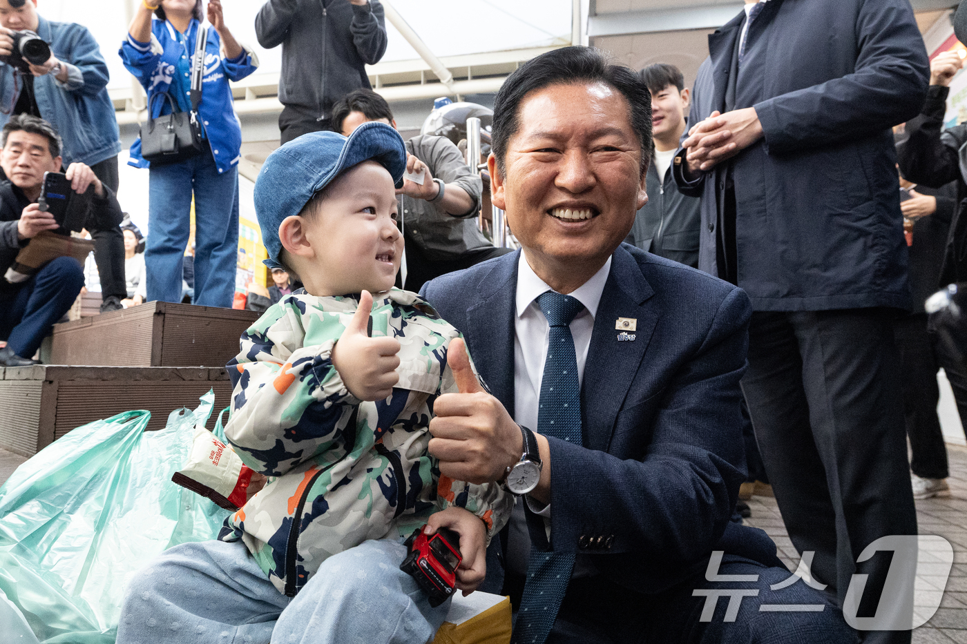 (속초=뉴스1) 이승배 기자 = 정청래 더불어민주당 대표가 12일 강원 속초관광수산시장에서 아이와 사진을 찍고 있다. 2026.4.12/뉴스1