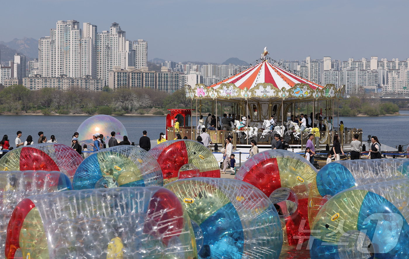 (서울=뉴스1) 김성진 기자 = 12일 서울 영등포구 여의도 한강공원에서 열린 2026 서울스프링페스티벌을 찾은 시민들이 회전목마를 탑승하고 있다. 2026.4.12/뉴스1