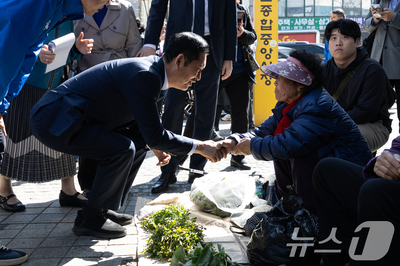(속초=뉴스1) 이승배 기자 = 정청래 더불어민주당 대표가 12일 강원 속초관광수산시장을 찾아 노점 상인과 인사하고 있다. 2026.4.12/뉴스1