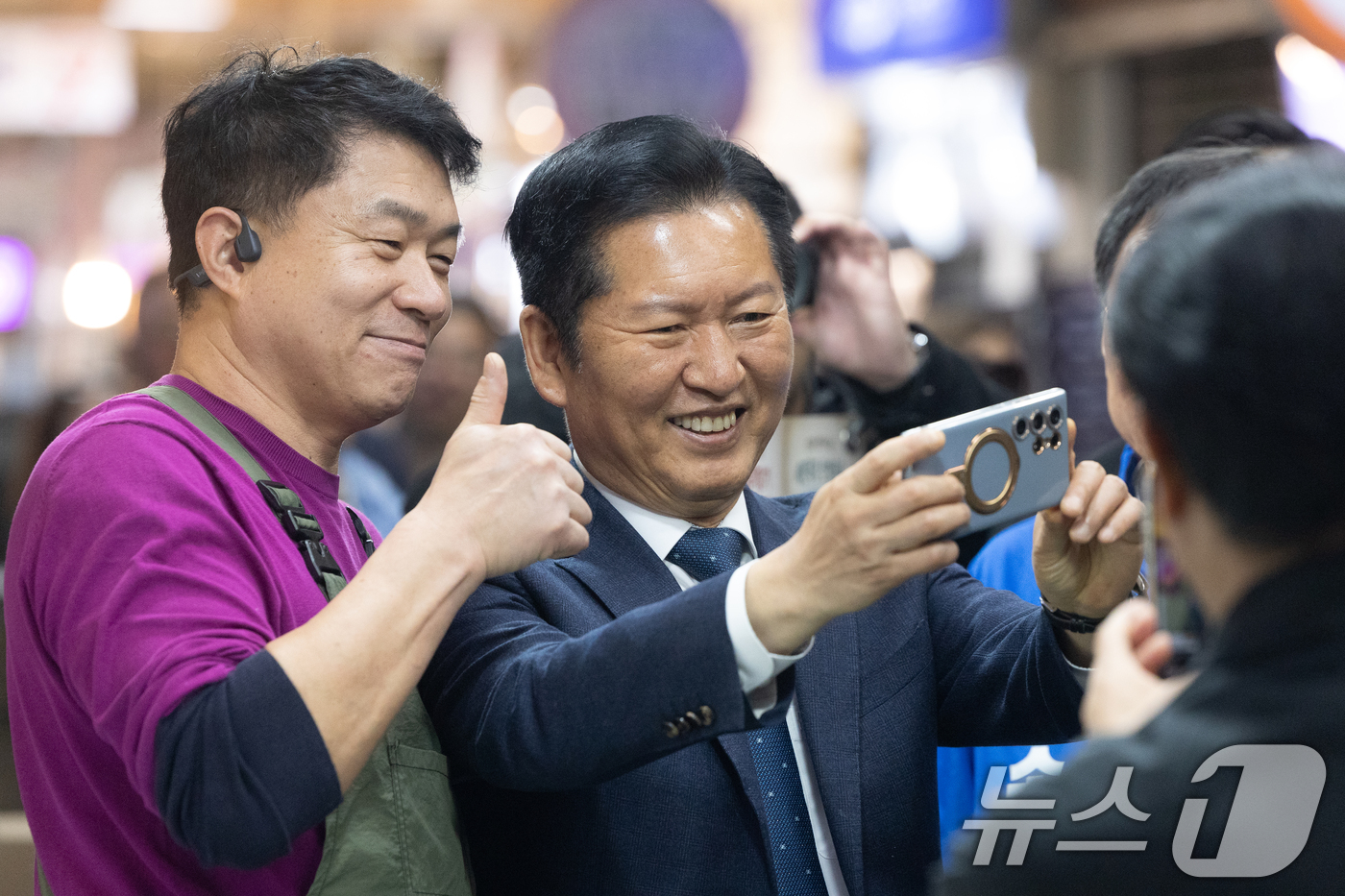 (속초=뉴스1) 이승배 기자 = 정청래 더불어민주당 대표가 12일 강원 속초관광수산시장을 찾아 상인과 셀카를 찍고 있다. 2026.4.12/뉴스1