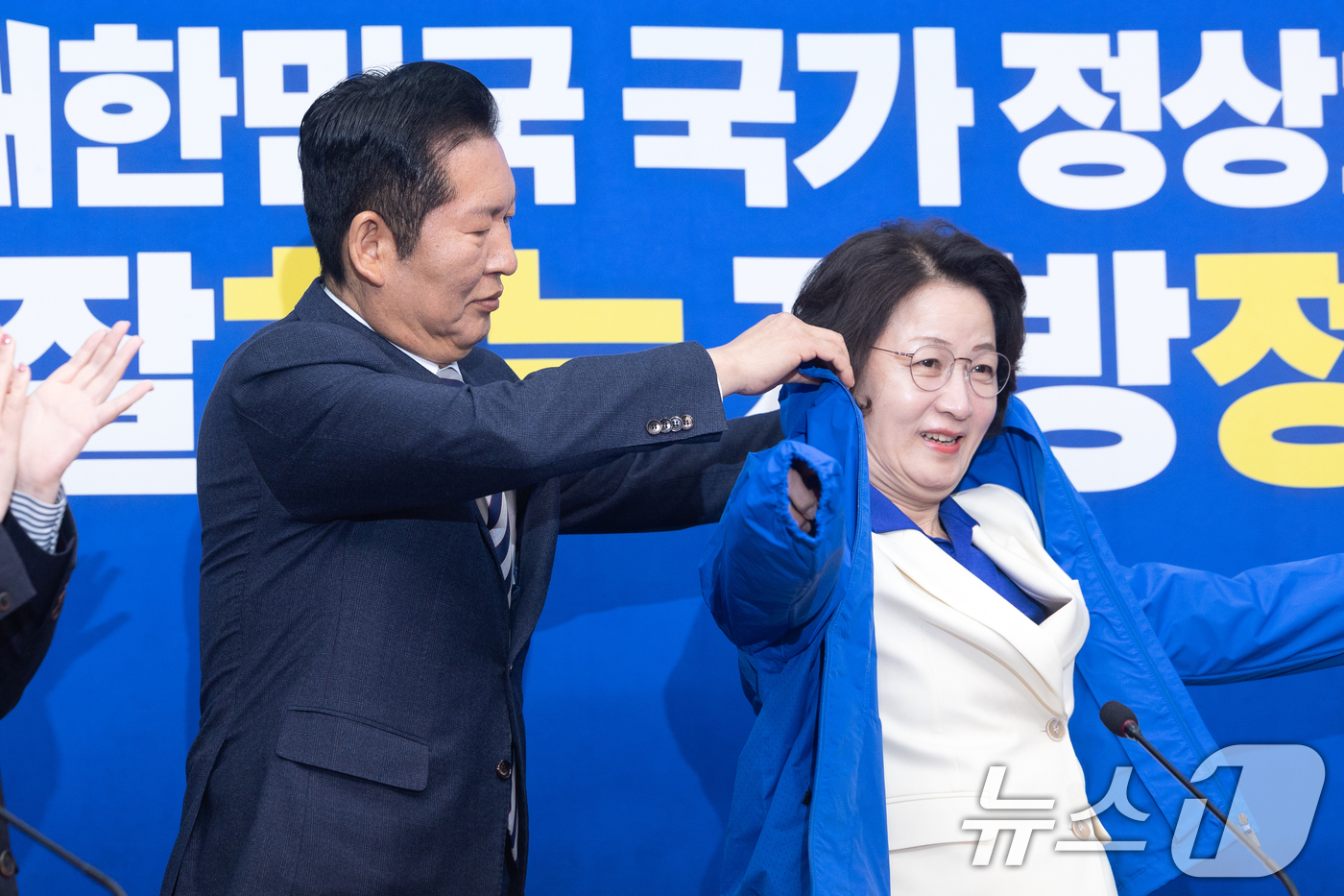 (서울=뉴스1) 이승배 기자 = 정청래 더불어민주당 대표가 13일 서울 여의도 국회에서 열린 경기도지사 후보 환영식에서 추미애 후보에게 당 점퍼를 입혀주고 있다. 2026.4.13 …