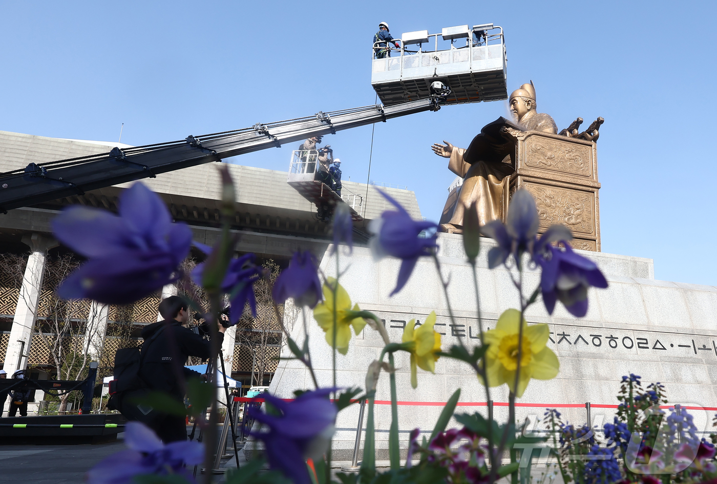 (서울=뉴스1) 김민지 기자 = 13일 오전 서울 종로구 세종로 광화문광장에서 세종대왕 동상을 세척 작업이 진행중인 가운데 외국인 관광객들이 이 모습을 지켜보고 있다. 2026.4 …