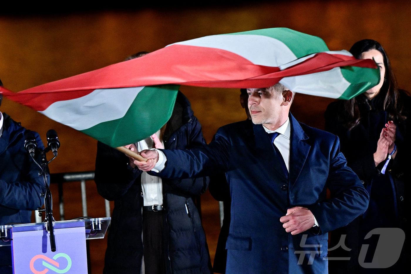 (부다페스트 로이터=뉴스1) 이창규 기자 = 12일(현지시간) 헝가리 총선에서 승리한 페테르 마자르 티사당 대표가 부다페스트에서 국기를 흔들고 있다. 2026.4.13./뉴스1ⓒ …