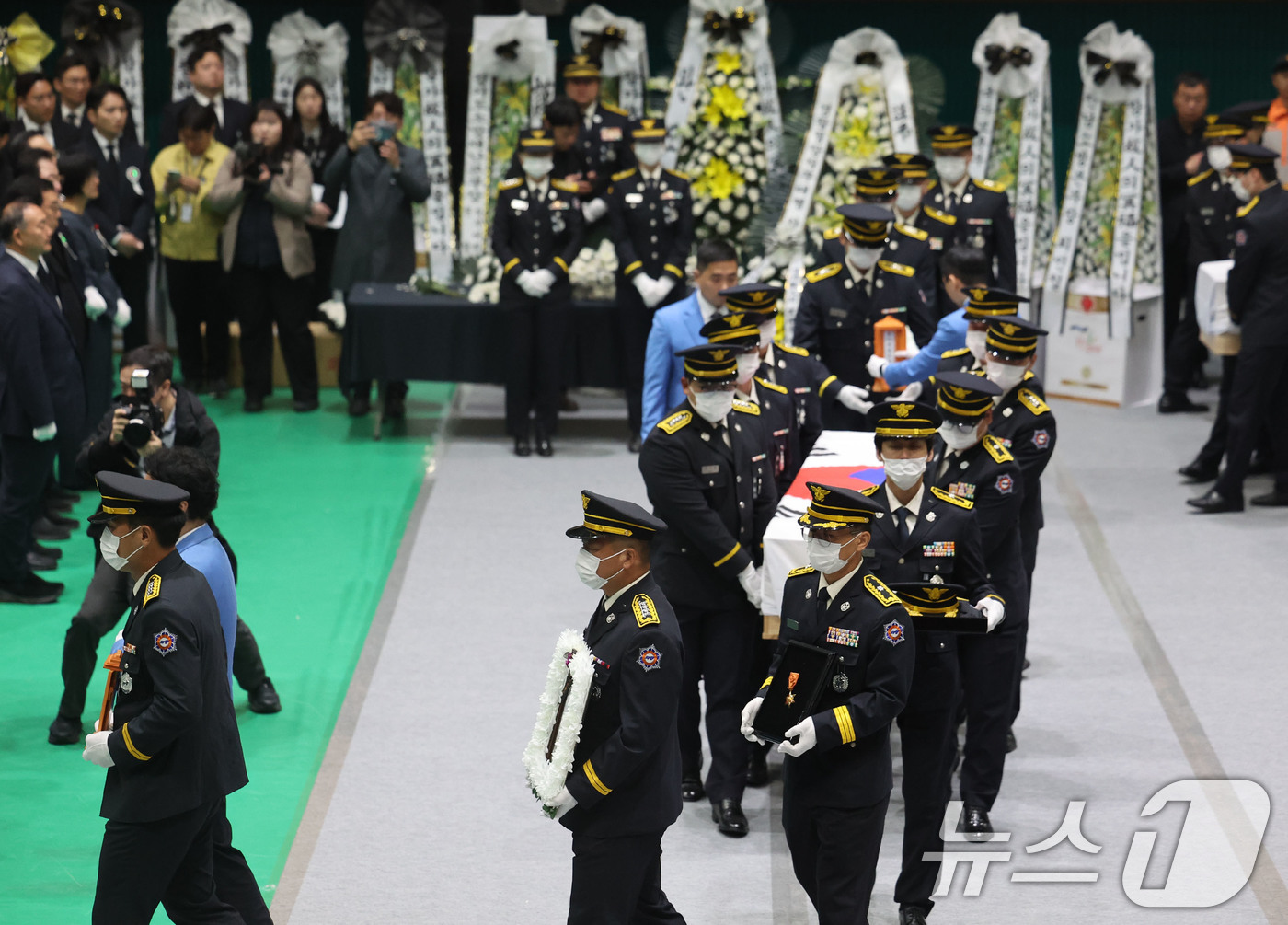 (완도=뉴스1) 박지현 기자 = 14일 전남 완도군 농어민문화체육센터에서 열린 순직 소방공무원 영결식에서 동료소방관들과 유족들이 마지막 가는 길을 배웅하고 있다. 2026.4.14 …