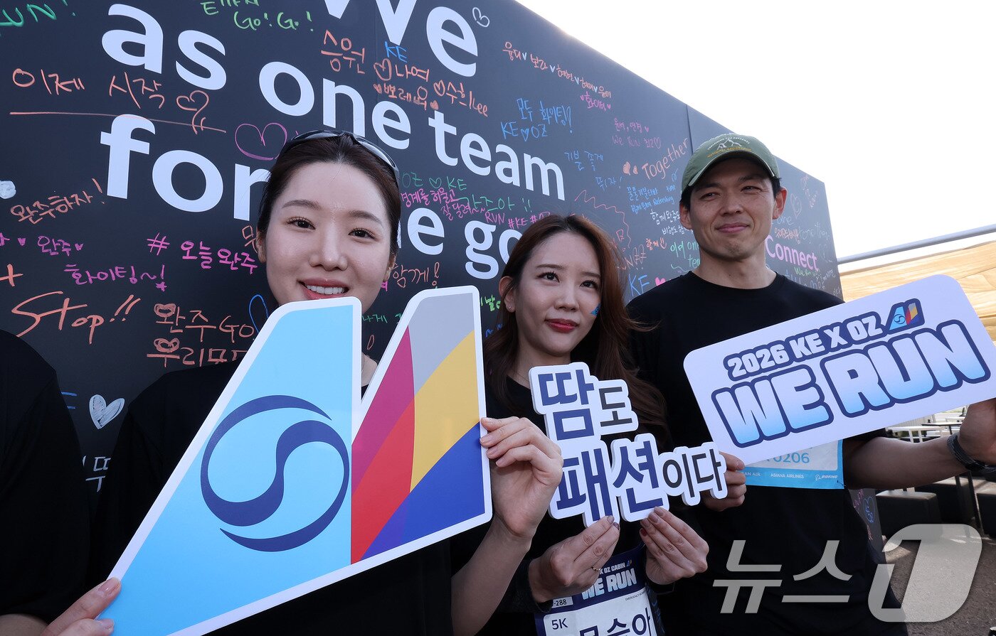 본문 이미지 - 지난달 14일 인천 중구 BMW 드라이빙센터에서 열린 대한항공·아시아나항공 객실승무원 화합 기부 러닝 행사 ‘WE RUN’ 참가자들이 메시지월 앞에서 포즈를 취한 모습. 대한항공과 아시아나항공은 통합 항공사 출범을 앞두고 양사 화합과 결속을 위한 자선 달리기 행사를 진행했다. 2026.4.14 ⓒ 뉴스1 박지혜 기자