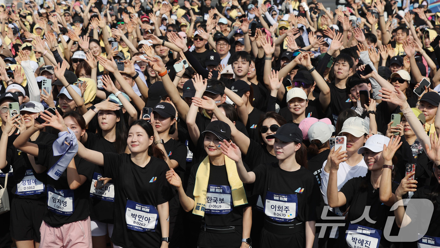 (인천=뉴스1) 박지혜 기자 = 14일 인천 중구 BMW 드라이빙센터에서 열린 대한항공·아시아나항공 객실승무원 화합 기부 러닝 행사 ‘WE RUN’에서 참가자들이 가수 션의 노래에 …