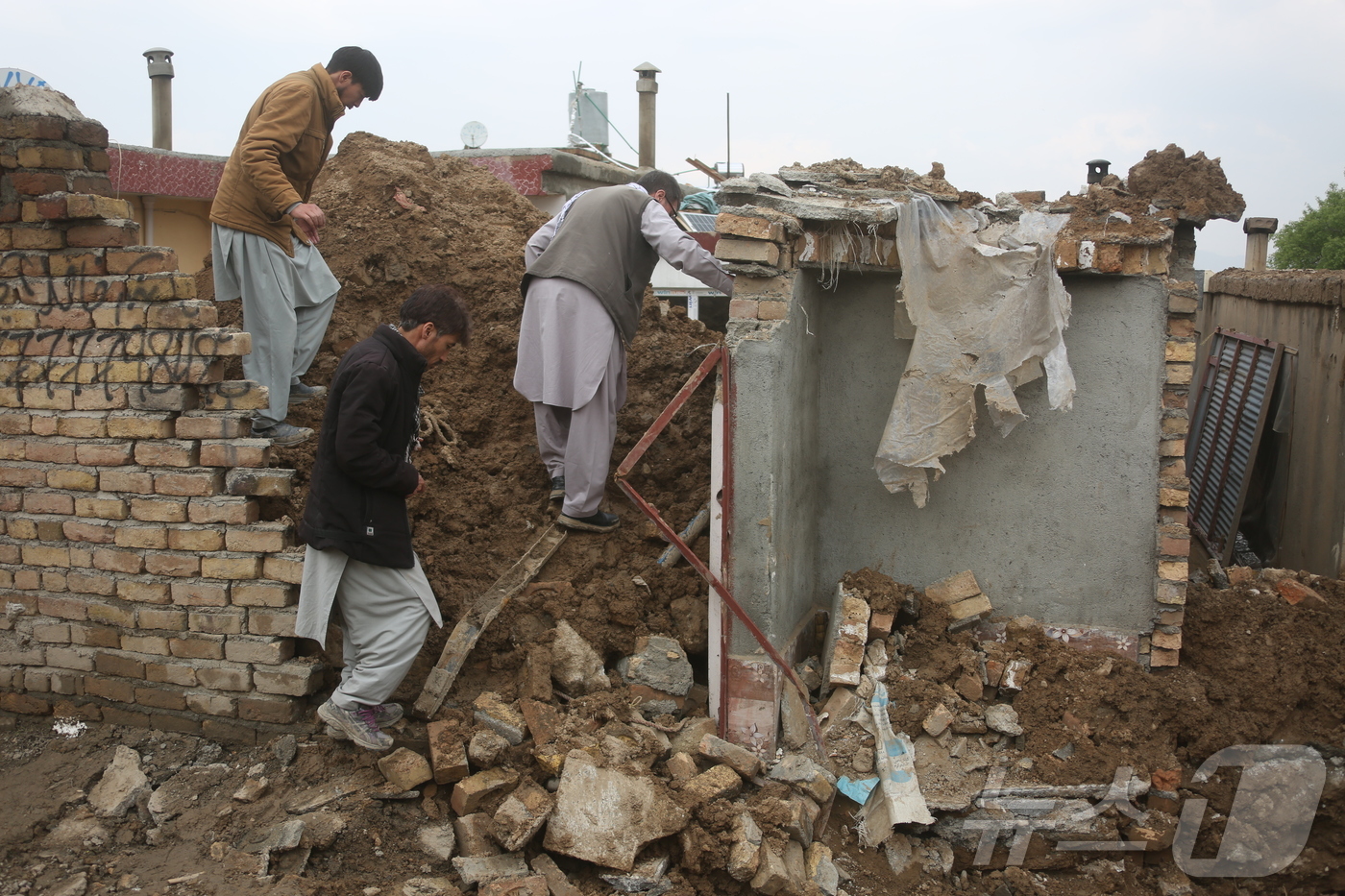 (카불 신화=뉴스1) 김경민 기자 = 아프가니스탄 시민들이 5일(현지시간) 수도 카불에서 폭우로 무너진 집을 확인하고 있다. 2026.4.5ⓒ 신화=뉴스1