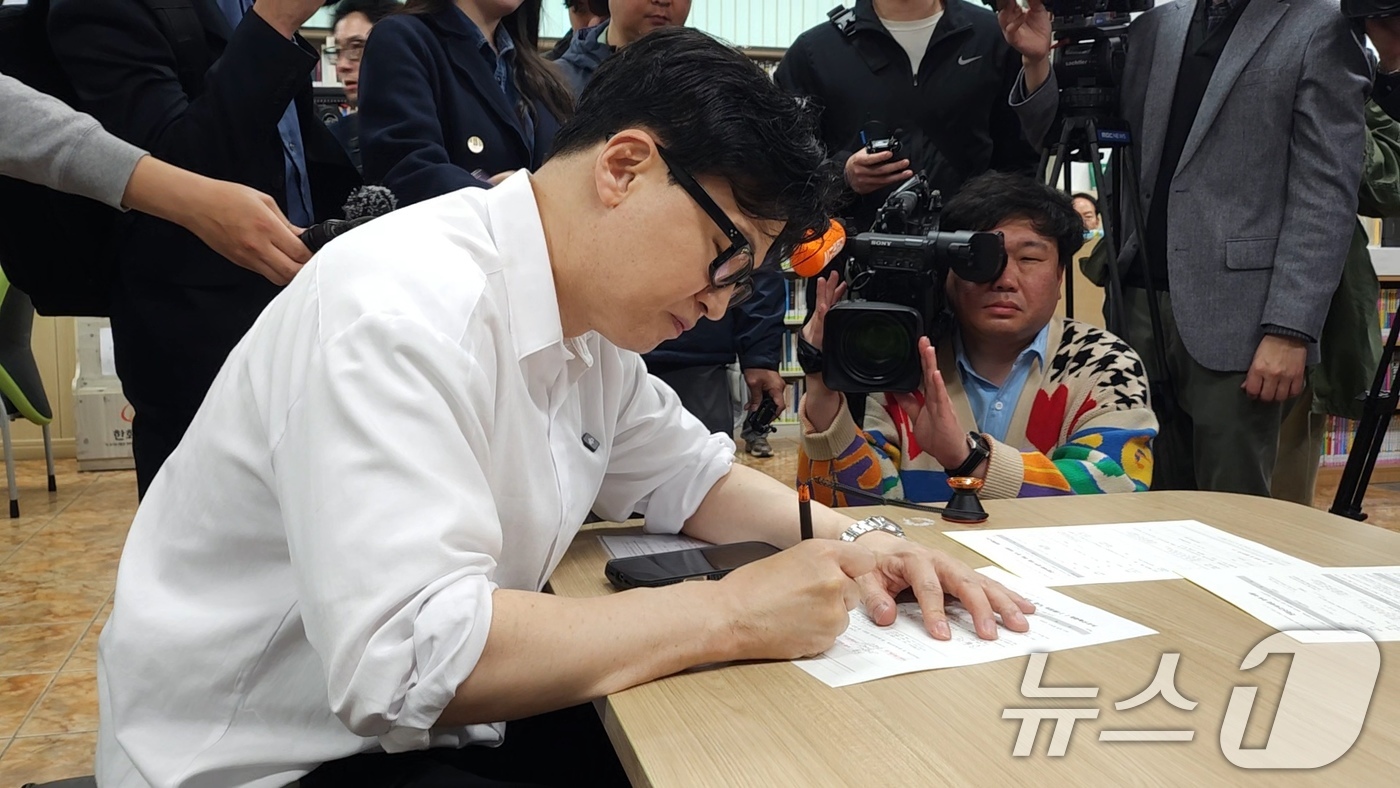(부산=뉴스1) = 한동훈 전 국민의힘 대표가 14일 부산 북구 만덕2동 주민센터에서 전입신고서에 서명하고 있다. (한 전 대표측 제공. 재판매 및 DB 금지) 2026.4.14/ …