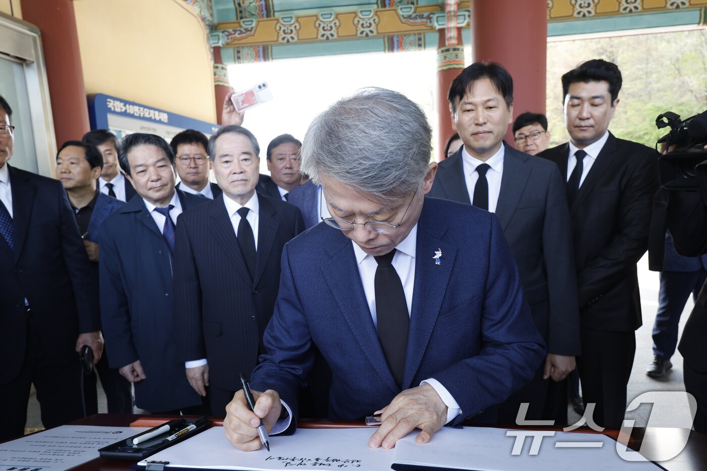 본문 이미지 - 민형배 더불어민주당 전남광주통합특별시장 후보가 15일 광주 국립5.18민주묘역을 찾아 참배에 앞서 방명록을 쓰고 있다. 2026.4.15 ⓒ 뉴스1 김태성 기자