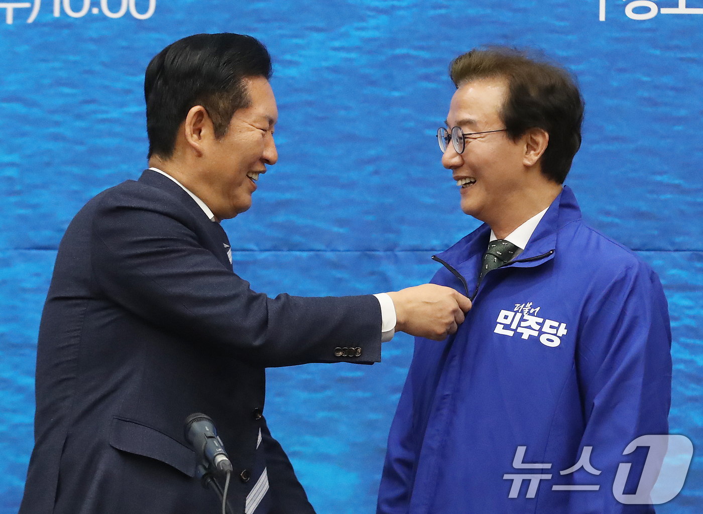 (부산=뉴스1) 윤일지 기자 = 정청래 더불어민주당 대표가 15일 부산 동구 부산항국제전시컨벤션센터에서 열린 부산 현장 최고위원회의에서 전재수 부산시장 후보에게 당 점퍼를 입혀주고 …