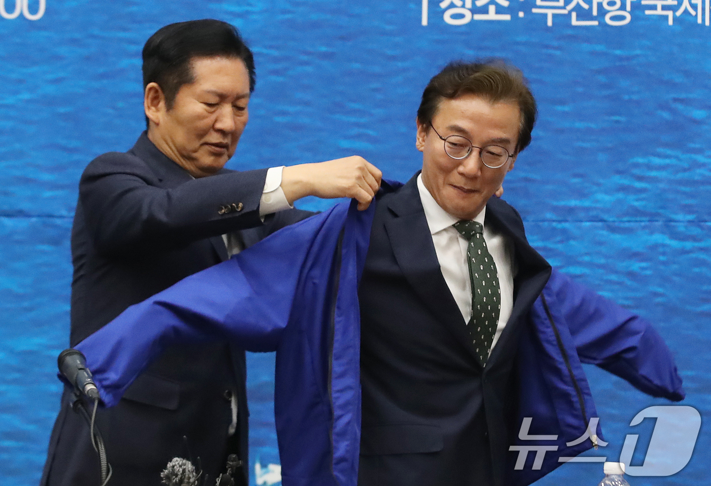 (부산=뉴스1) 윤일지 기자 = 정청래 더불어민주당 대표가 15일 부산 동구 부산항국제전시컨벤션센터에서 열린 부산 현장 최고위원회의에서 전재수 부산시장 후보에게 당 점퍼를 입혀주고 …