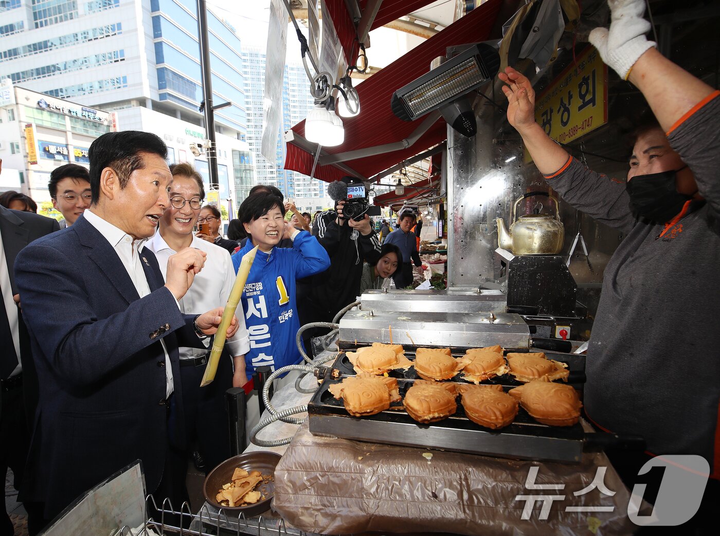 본문 이미지 - 정청래 더불어민주당 대표와 전재수 부산시장 후보가 15일 부산 부산진구 부전시장을 찾아 상인과 인사하고 있다. 2026.4.15 ⓒ 뉴스1 윤일지 기자