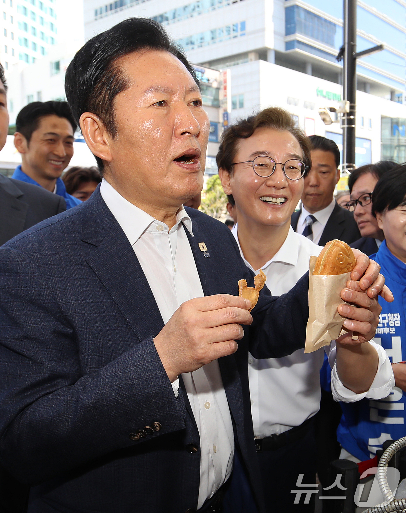 (부산=뉴스1) 윤일지 기자 = 정청래 더불어민주당 대표와 전재수 부산시장 후보가 15일 부산 부산진구 부전시장을 찾아 붕어빵을 구입하며 맛보고 있다. 2026.4.15/뉴스1