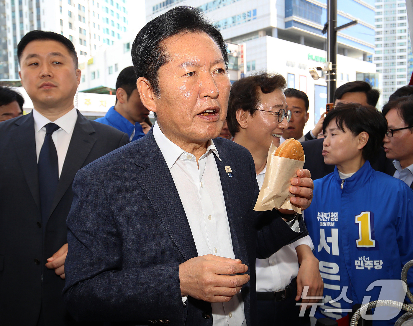 (부산=뉴스1) 윤일지 기자 = 정청래 더불어민주당 대표가 15일 부산 부산진구 부전시장을 찾아 붕어빵을 구입하며 맛보고 있다. 2026.4.15/뉴스1