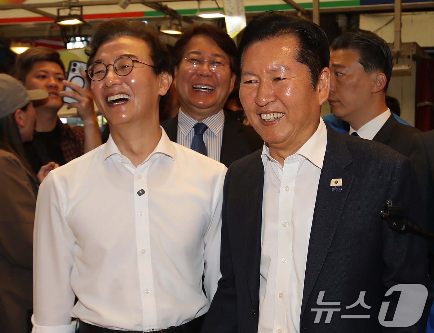 본문 이미지 - 정청래 더불어민주당 대표와 전재수 부산시장 후보가 15일 부산 부산진구 부전시장을 찾아 상인과 인사하고 있다. 2026.4.15 ⓒ 뉴스1 윤일지 기자