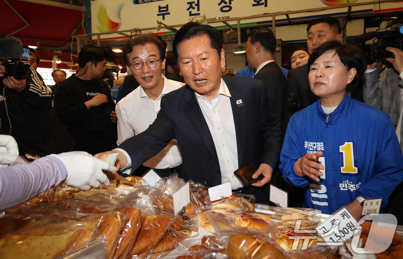 (부산=뉴스1) 윤일지 기자 = 정청래 더불어민주당 대표가 15일 부산 부산진구 부전시장을 찾아 빵을 구입하고 있다. 2026.4.15/뉴스1