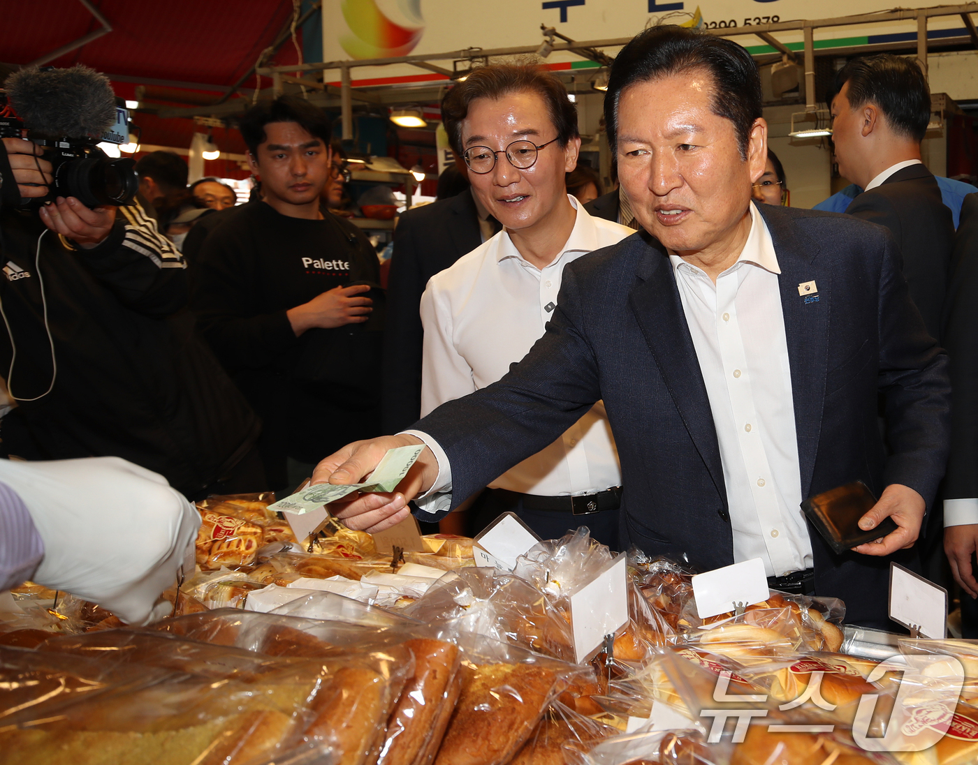 (부산=뉴스1) 윤일지 기자 = 정청래 더불어민주당 대표가 15일 부산 부산진구 부전시장을 찾아 빵을 구입하고 있다. 2026.4.15/뉴스1