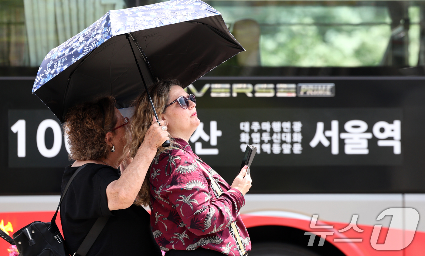 (서울=뉴스1) 최지환 기자 = 서울 낮 최고 기온이 26도까지 오르는 등 초여름 날씨가 이어지는 15일 서울 종로구 광화문광장에서 외국인 관광객이 양산으로 태양을 피하고 있다. …