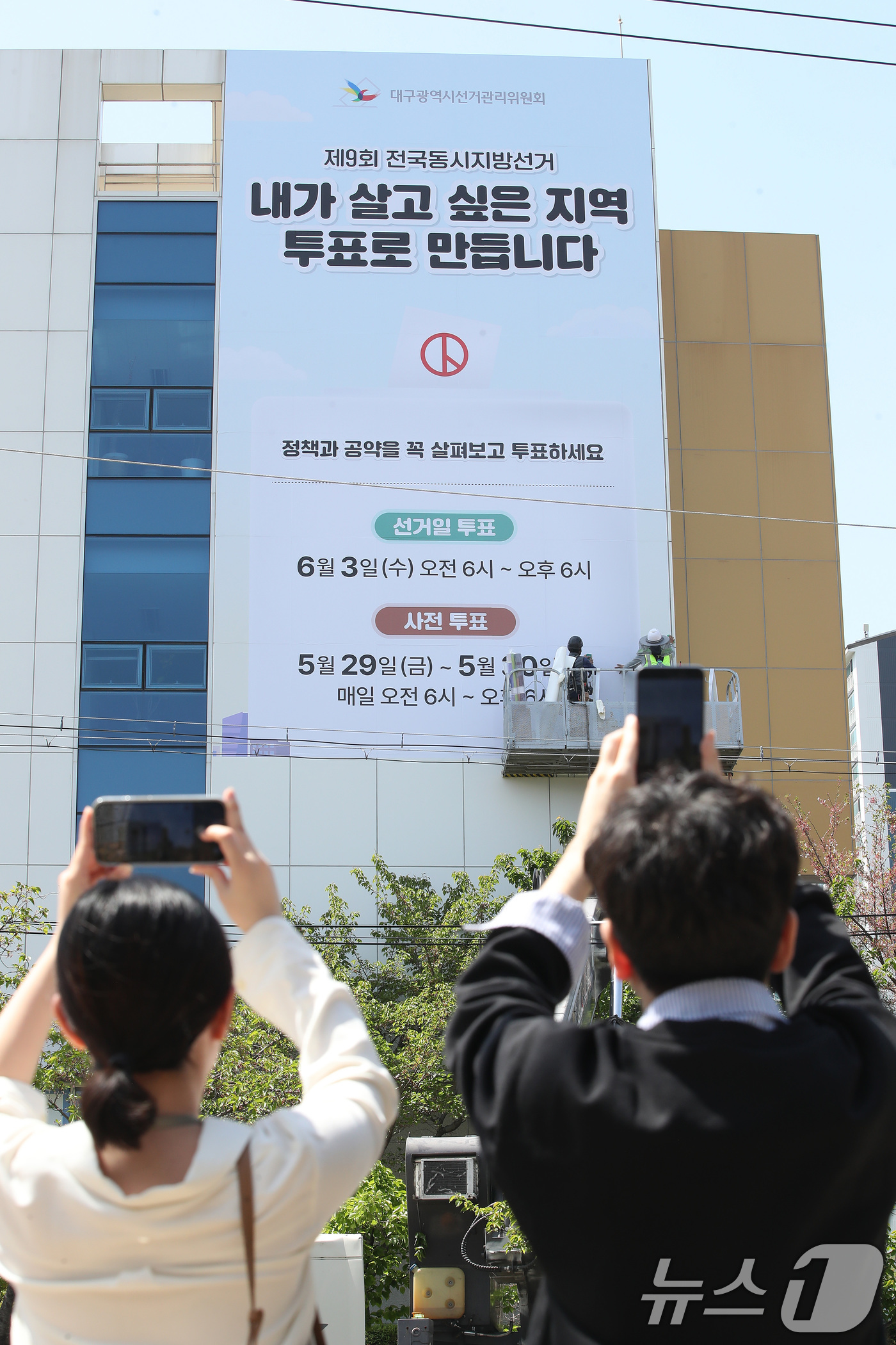 (대구=뉴스1) 공정식 기자 = 15일 대구 서구 대구시선거관리위원회 청사 외벽에 오는 6월 3일 실시되는 제9회 전국동시지방선거를 알리는 래핑 작업이 진행되고 있다. 2026.4 …