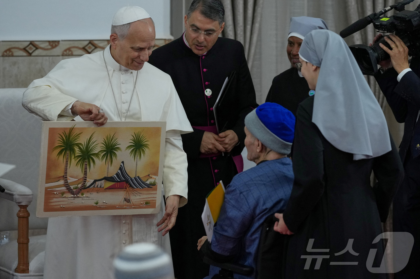 (안나바 로이터=뉴스1) 윤다정 기자 = 14일(현지시간) 알제리 안나바에 위치한 '가난한 이들의 작은 자매회' 요양원을 찾은 레오 14세 교황이 선물을 받고 있다. 2026.04 …