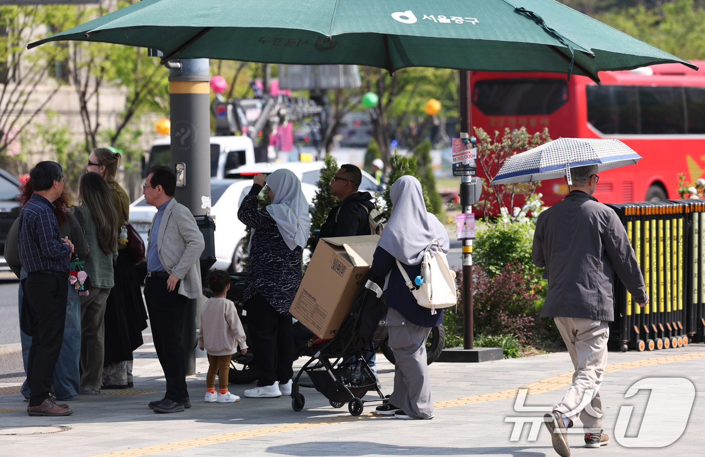(서울=뉴스1) 임지훈 인턴기자 = 낮 최고기온이 26도까지 오르는 등 초여름 같은 날씨를 보인 15일 오후 서울 중구 시청역 인근에서 시민들이 그늘막에서 횡단보도 신호를 기다리고 …